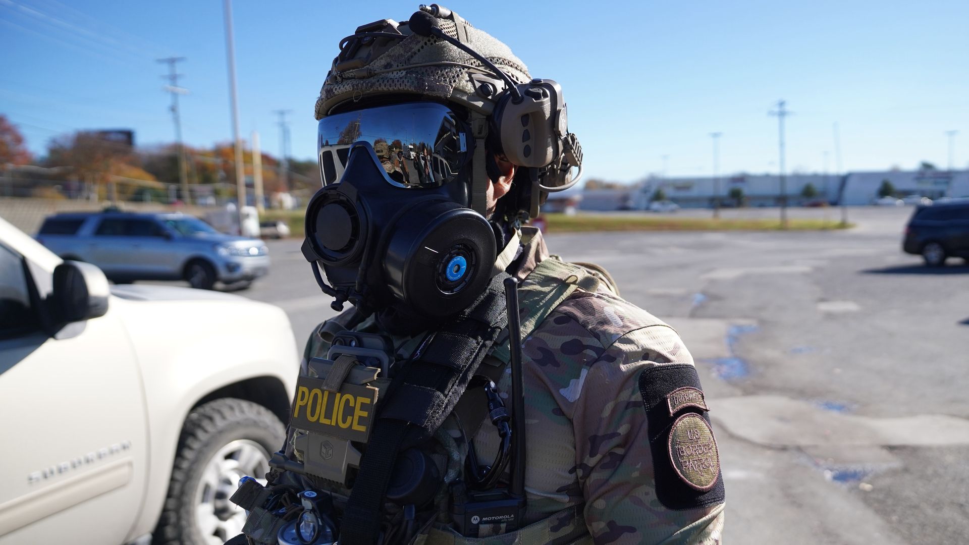 A U.S. Border Patrol agent surveys the parking lot of a grocery store