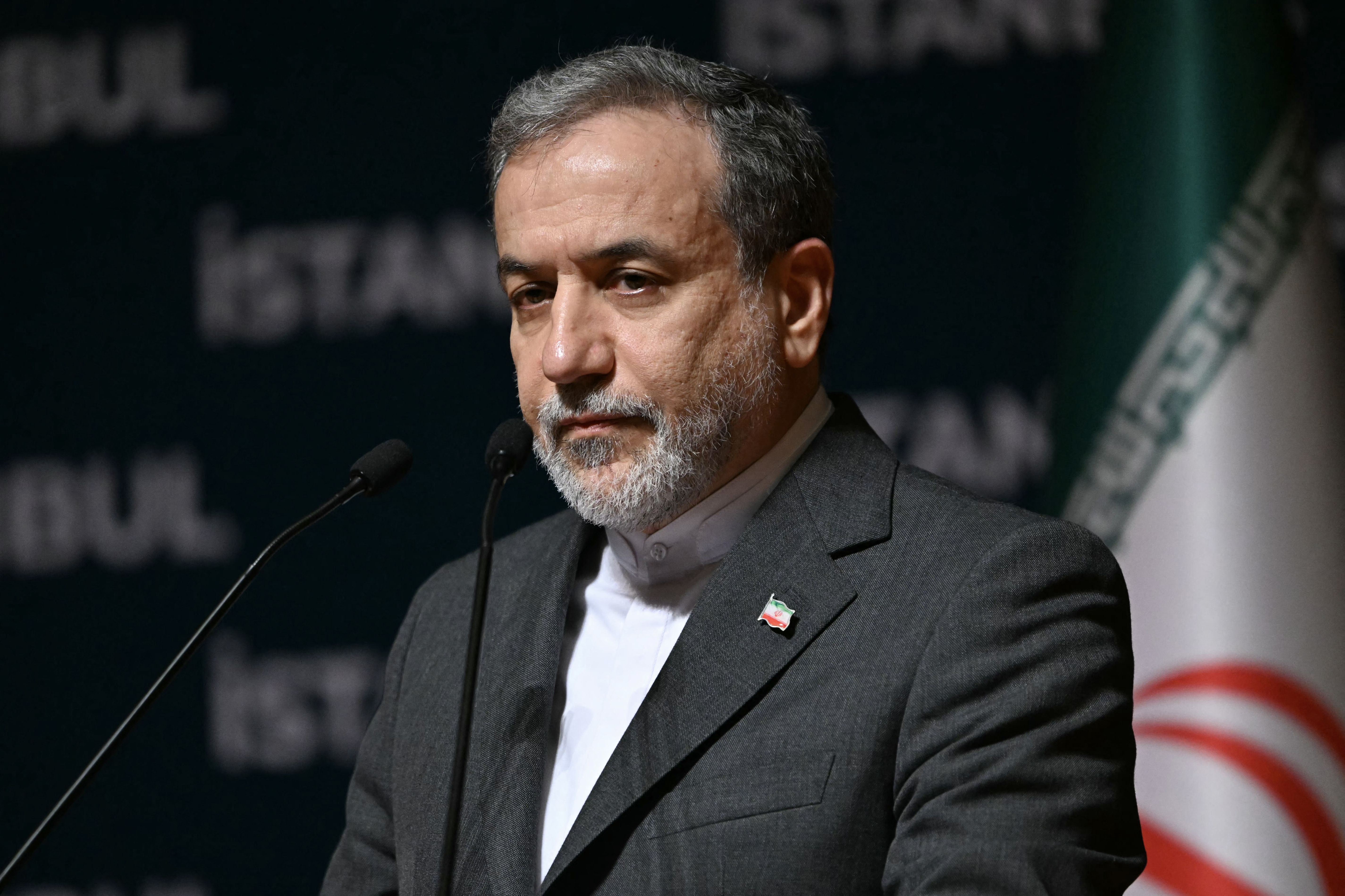 Iran Foreign Minister Abbas Araghchi at a podium during a press conference at an international meeting in Istanbul.