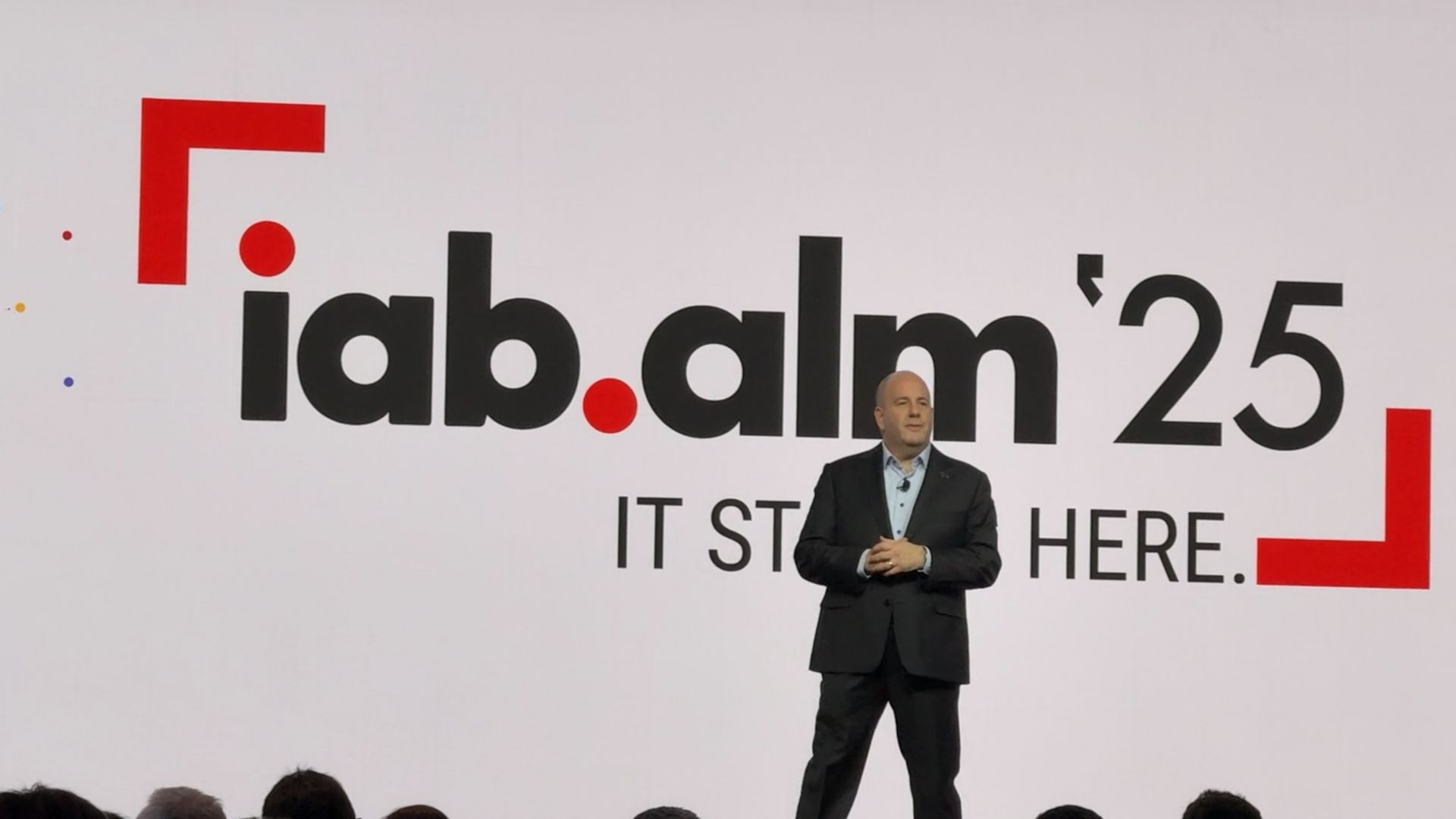 IAB CEO David Cohen standing in front of a screen that says IAB ALM '25 and It Starts Here