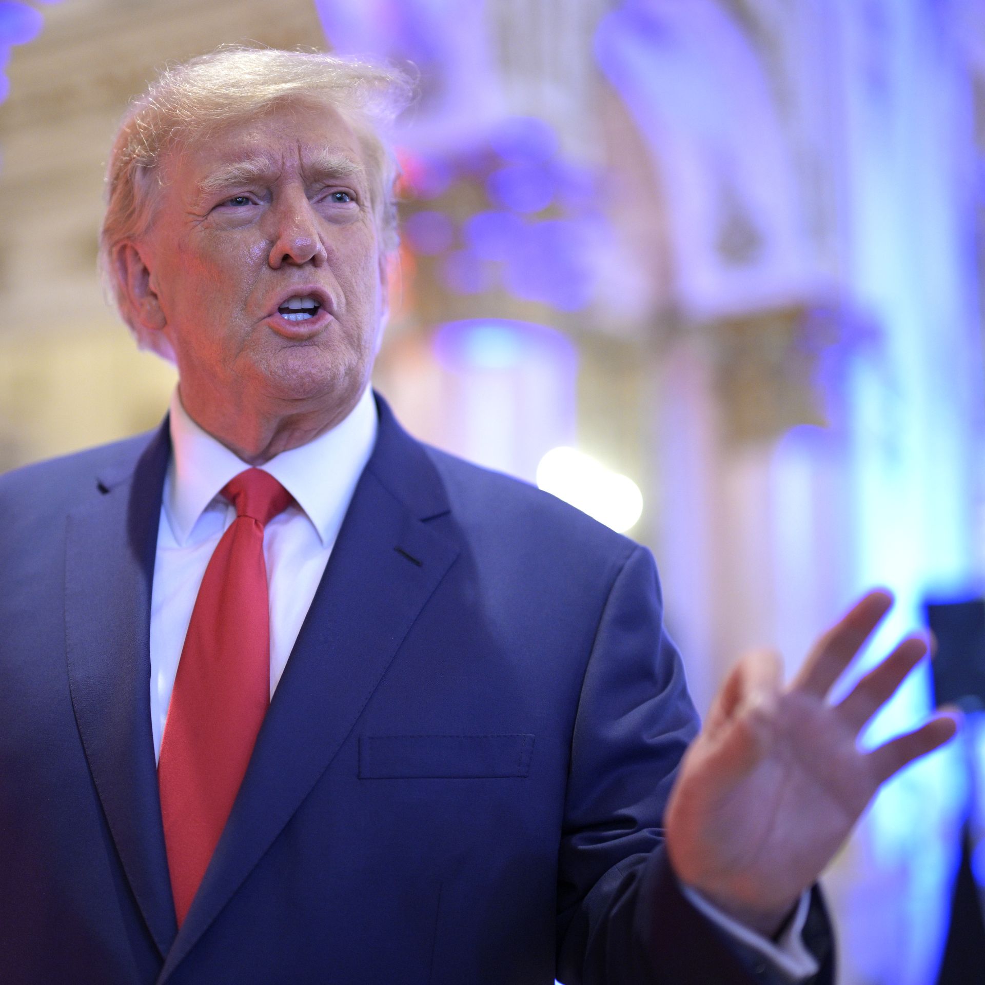 A close-up of Donald Trump talking and gesturing with his left hand