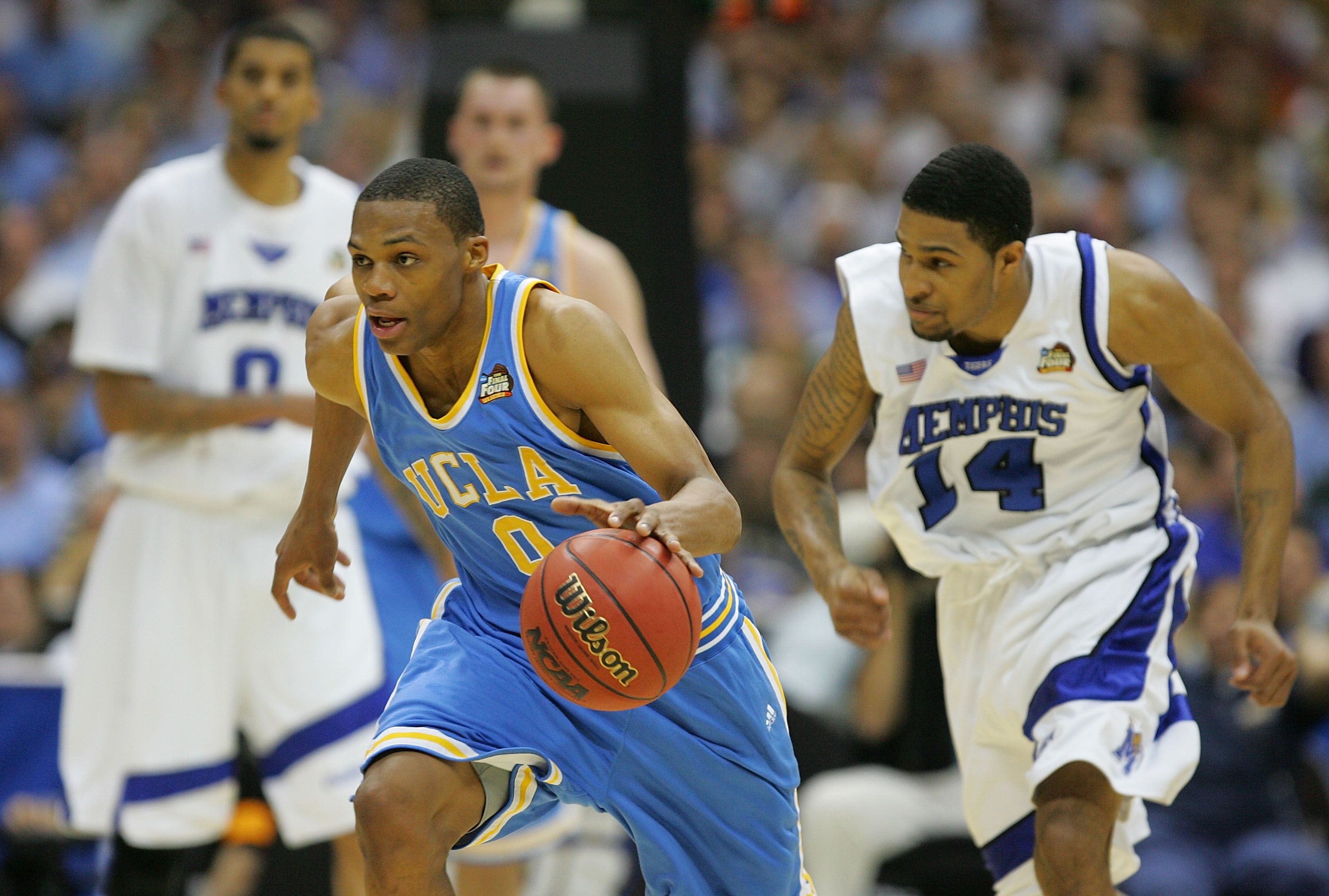 A man moves forward while holding an orange basketball.