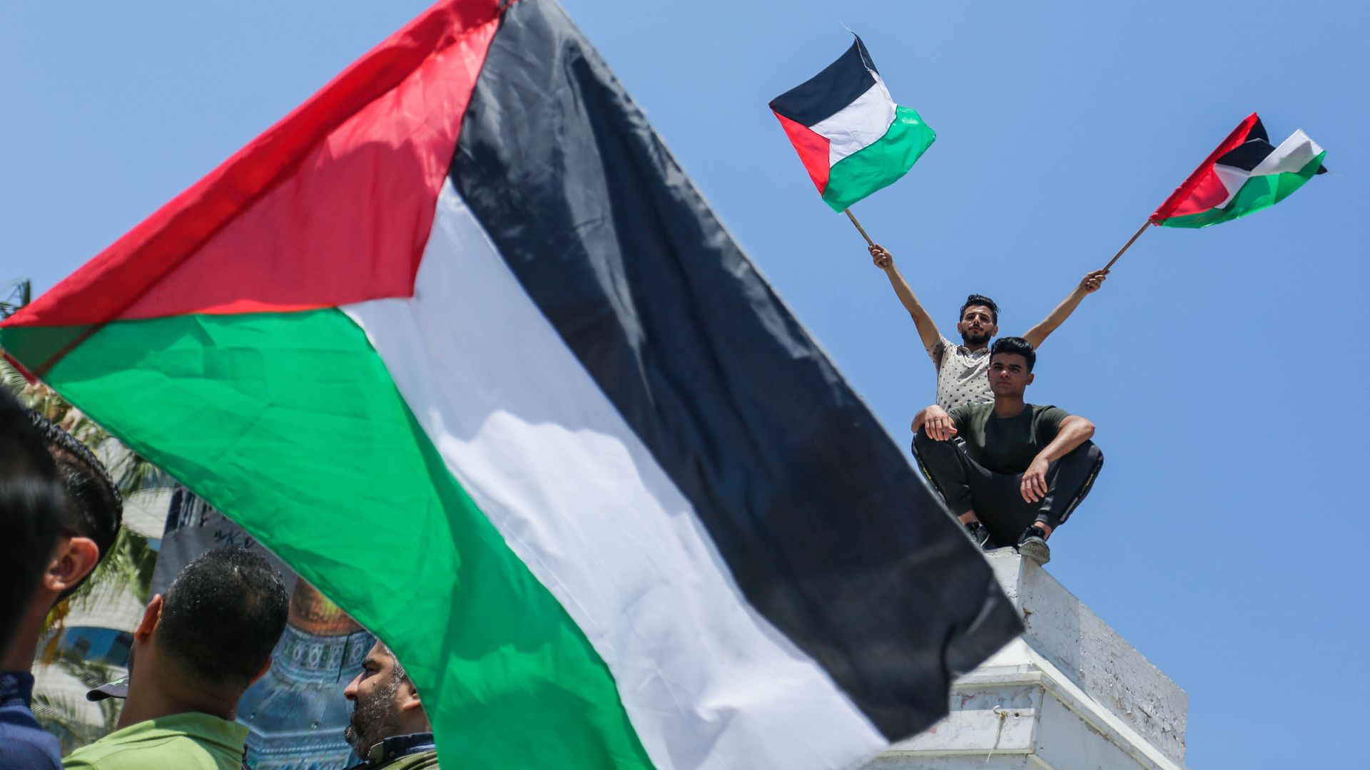 Palestinians wave flags at a demonstration in Gaza. 