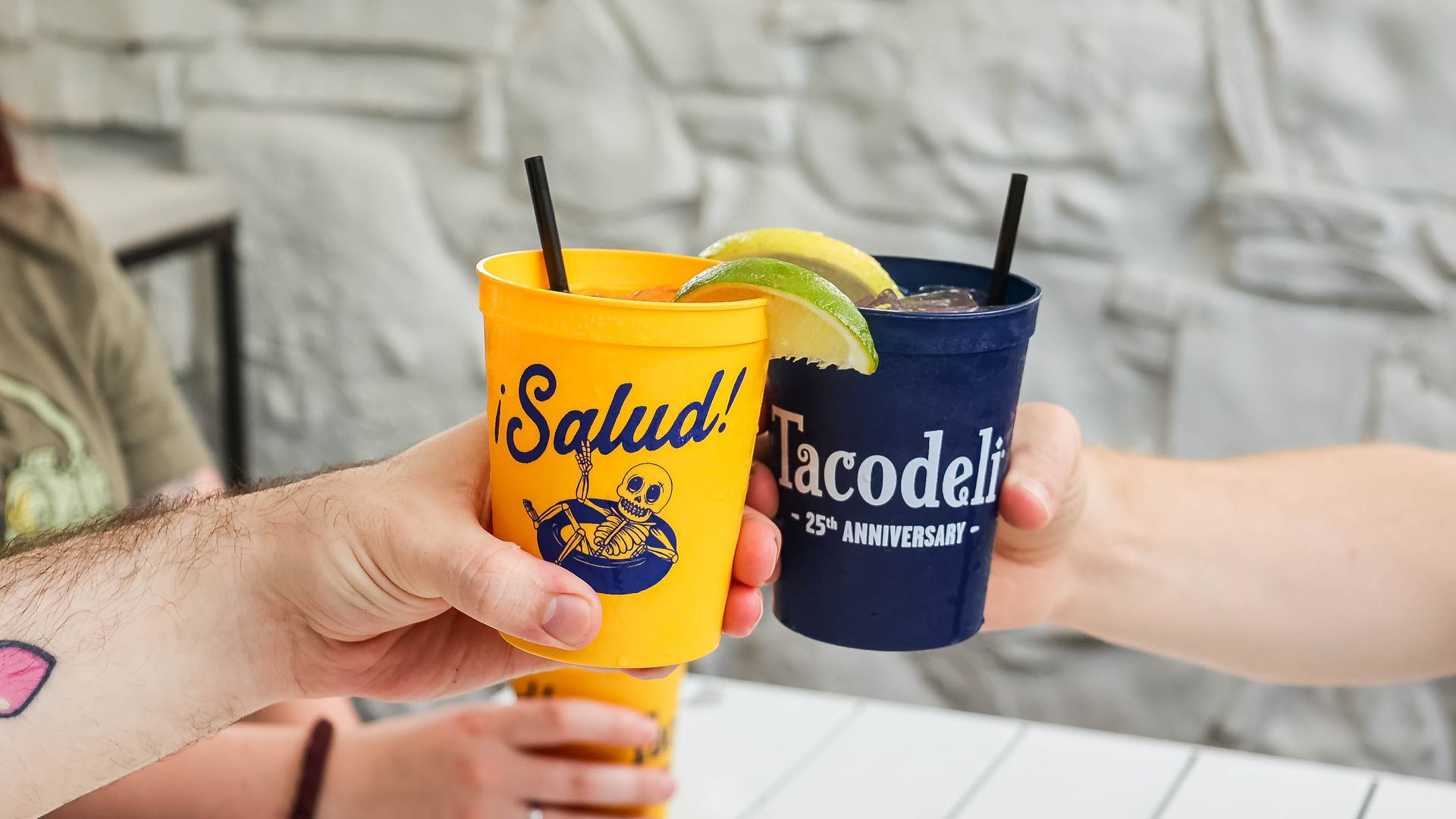A photo of two drinks reading "Salud!" and "Tacodeli."