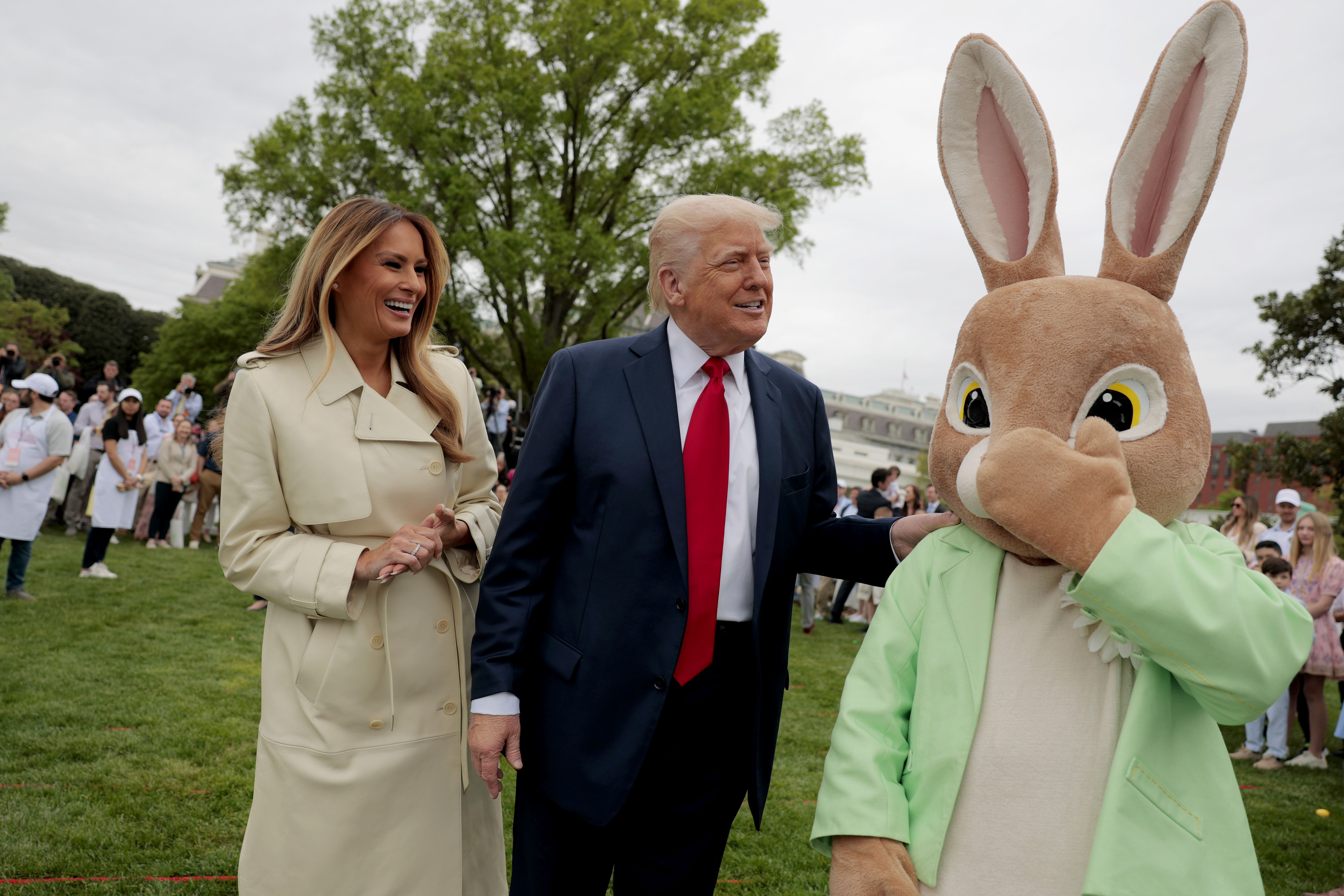 Donald and Melania Trump smile at a person dressed as the Easter Bunny.