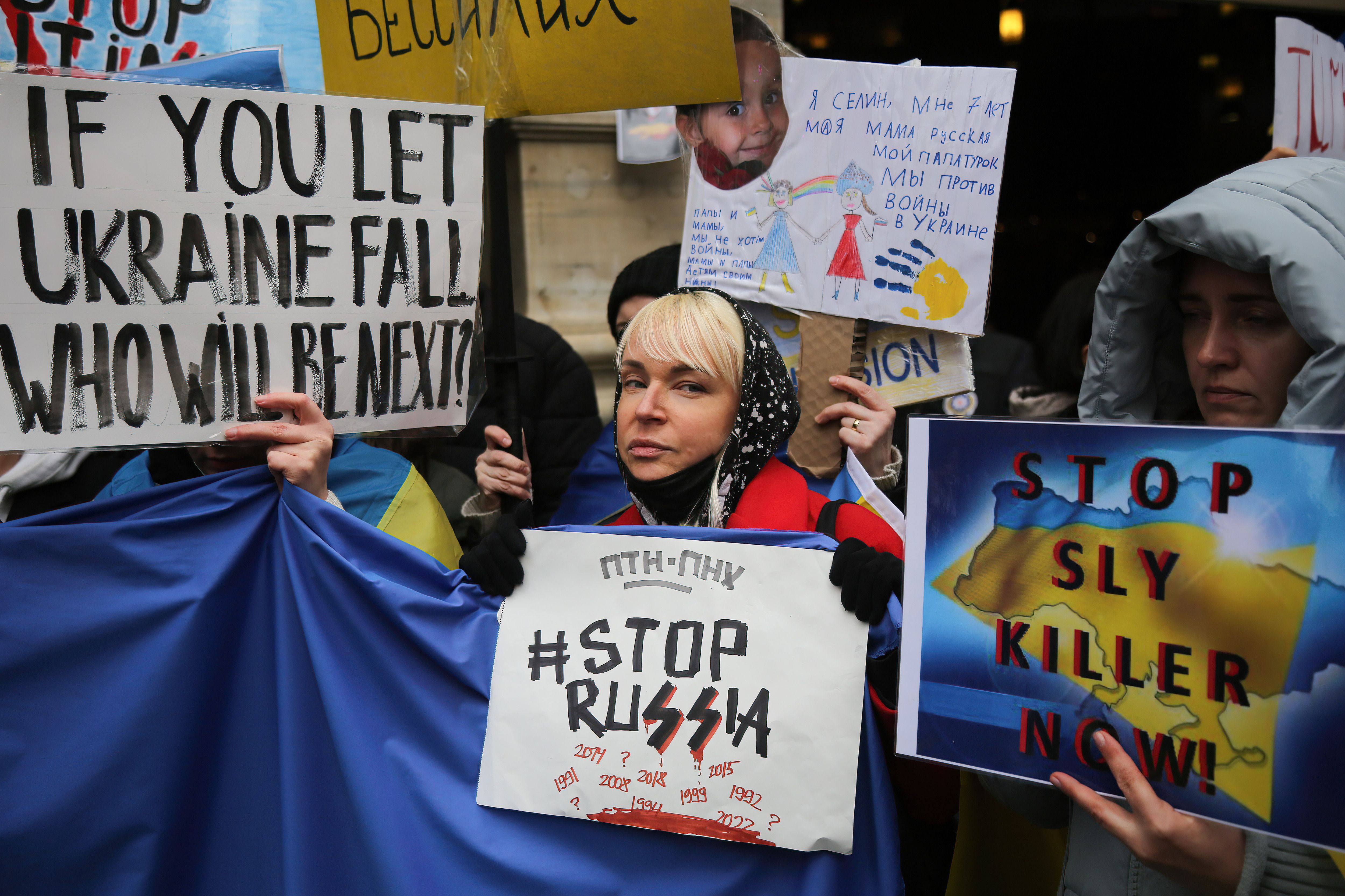 Photo of people holding signs that say "#StopRussia" and "If you let Ukraine fall, who will be next?"