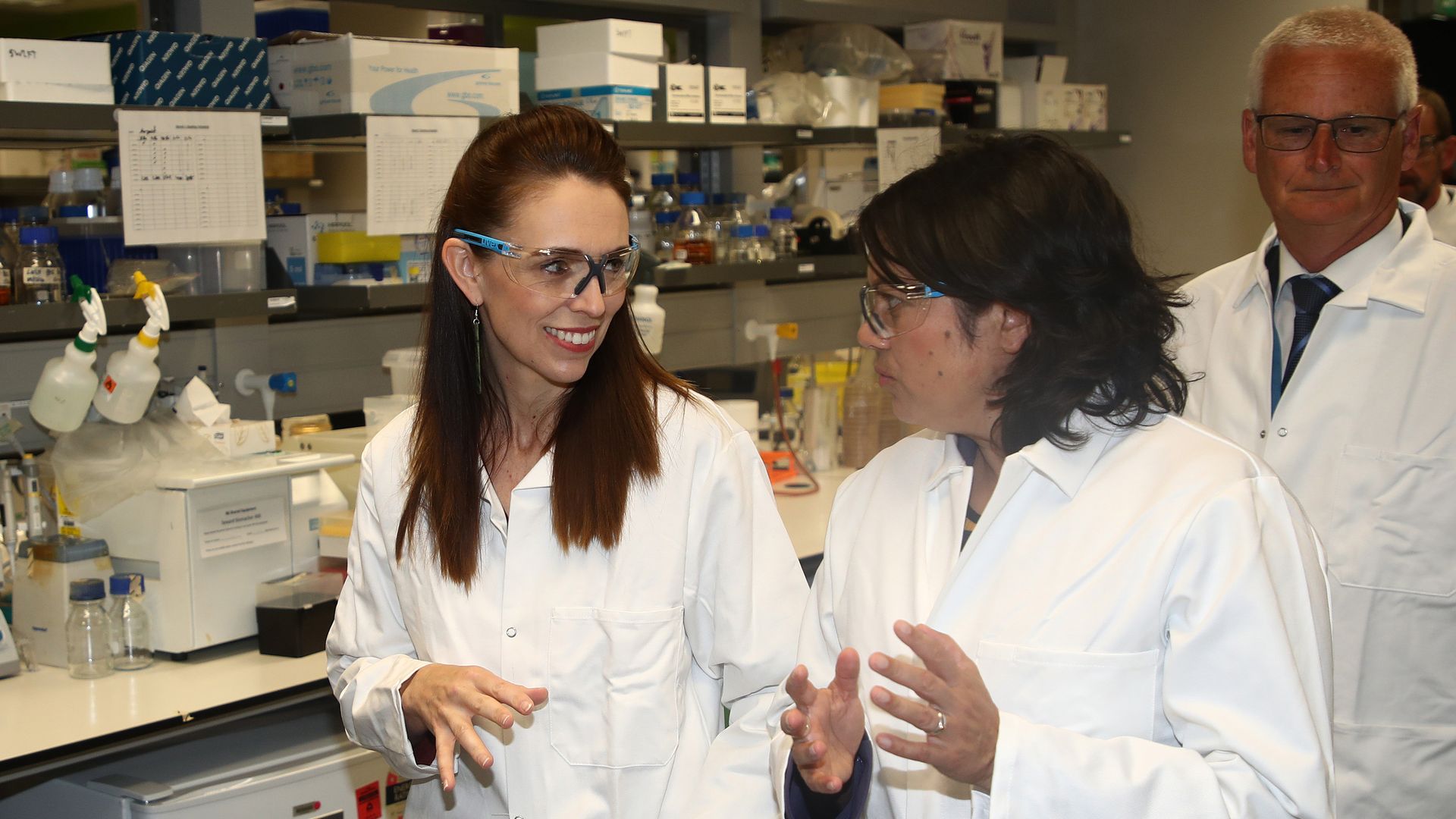 New Zealand Prime Minister Jacinda Ardern (L) visits a lab at Auckland University on December 17