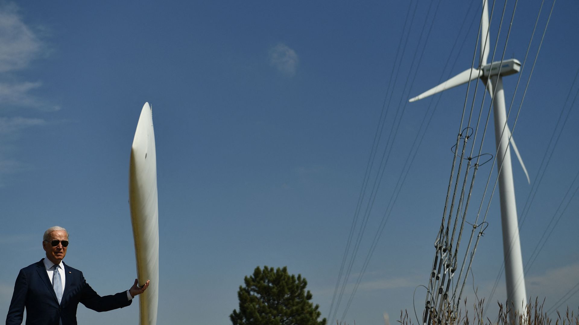President Biden is seen feeling a wind turbine blade while visiting a clean energy site in Colorado.