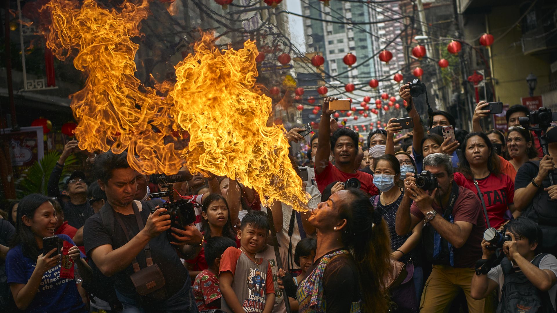 In this image, a man breathes fire as a dragon dancer celebrating the Lunar New Year