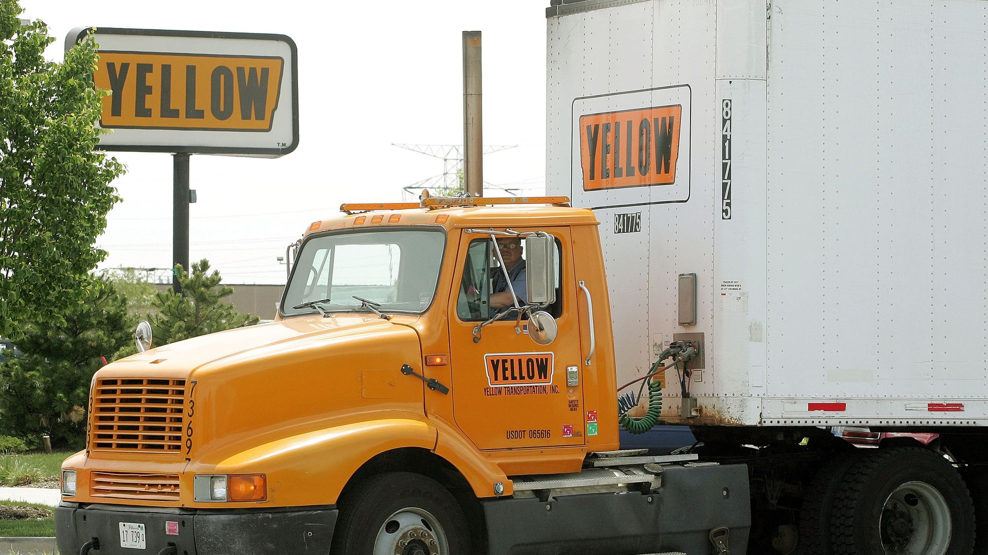 A Yellow truck leaves the truck terminal