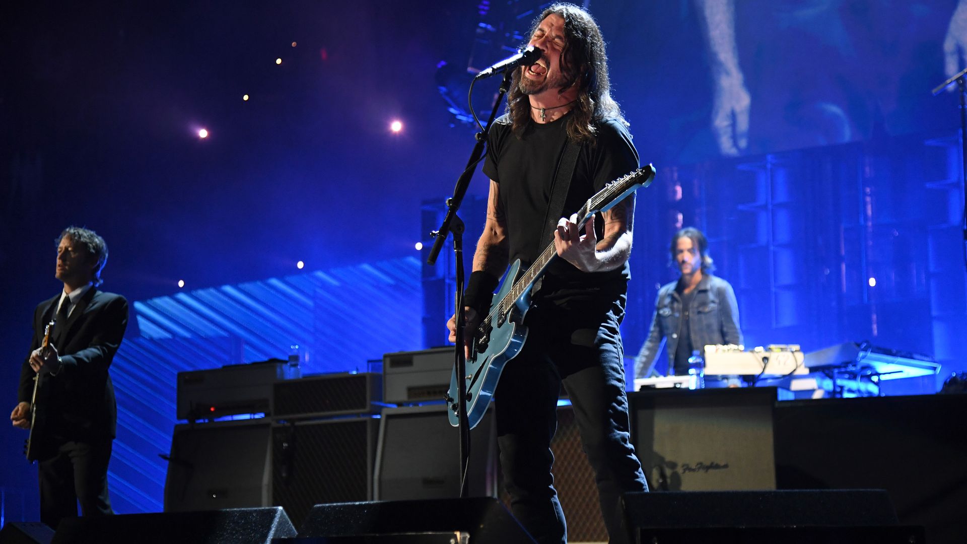 Dave Grohl of the Foo Fighters singing and playing a guitar at the Rock & Roll Hall of Fame Induction Ceremony.
