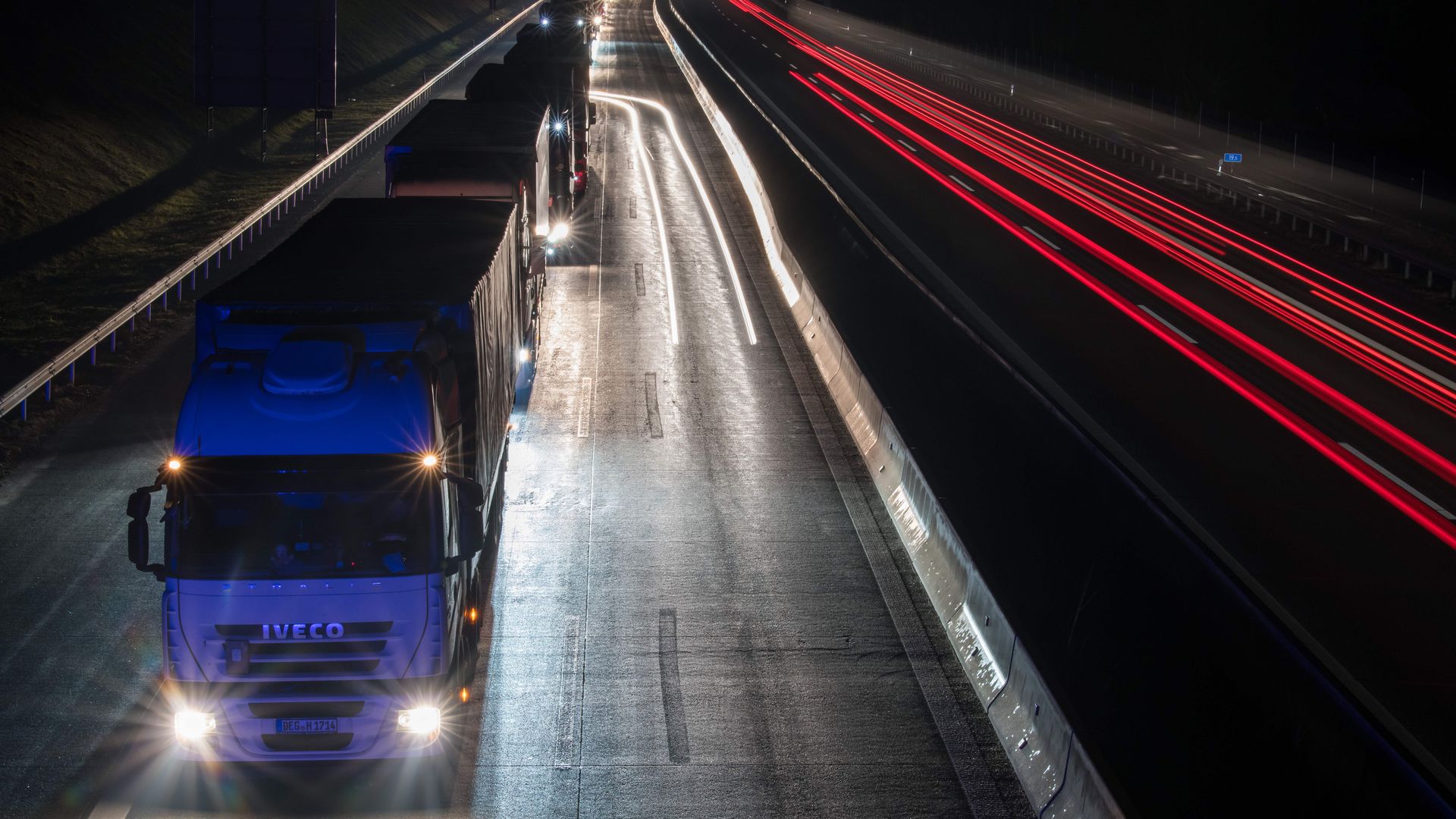 Trucks lined up on a highway at night