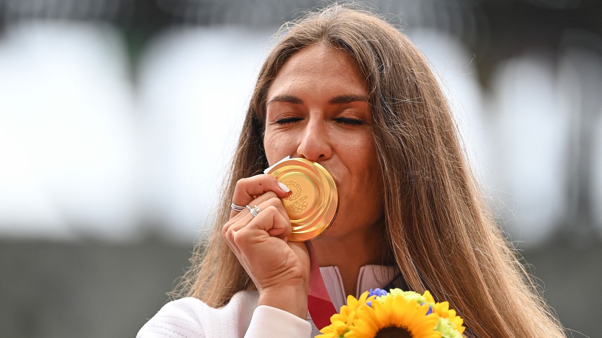 American Valarie Allman celebrates on the podium with her gold medal after winning the women's discus throw event at the Olympic Stadium in Tokyo on Aug. 3.