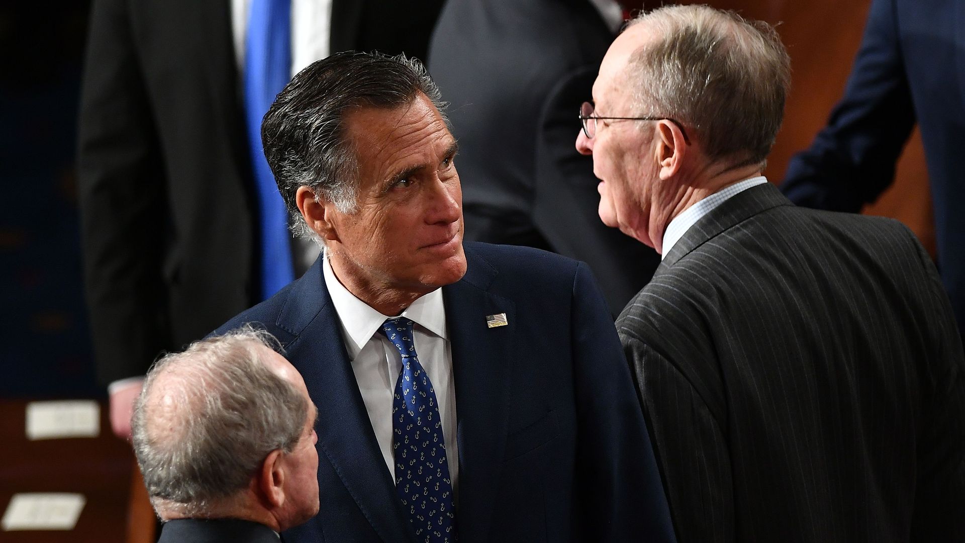 In this image, Mitt Romney stands in the Capitol during the impeachment trial next to two other senators