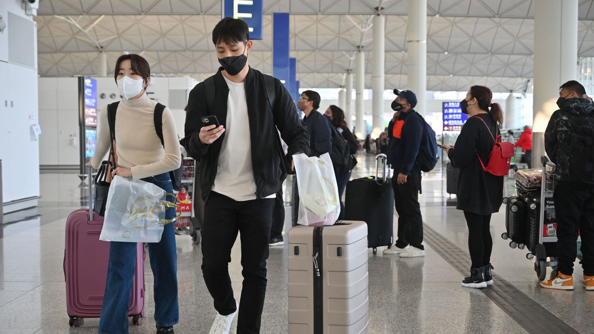 Passengers head to check-in counters at the international airport in Hong Kong on December 28, 2022.