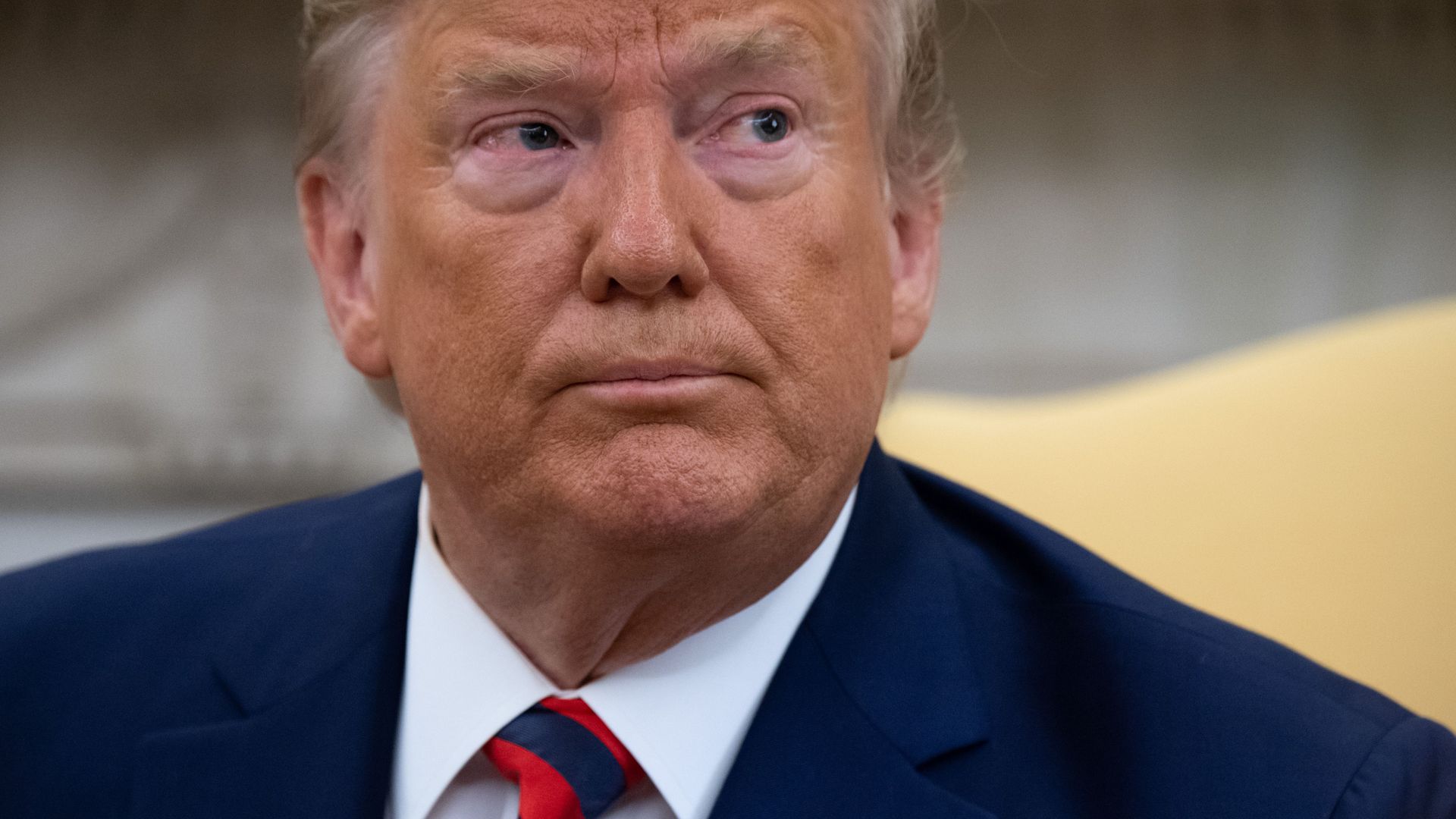 In this image, Trump sits and looks to the right.