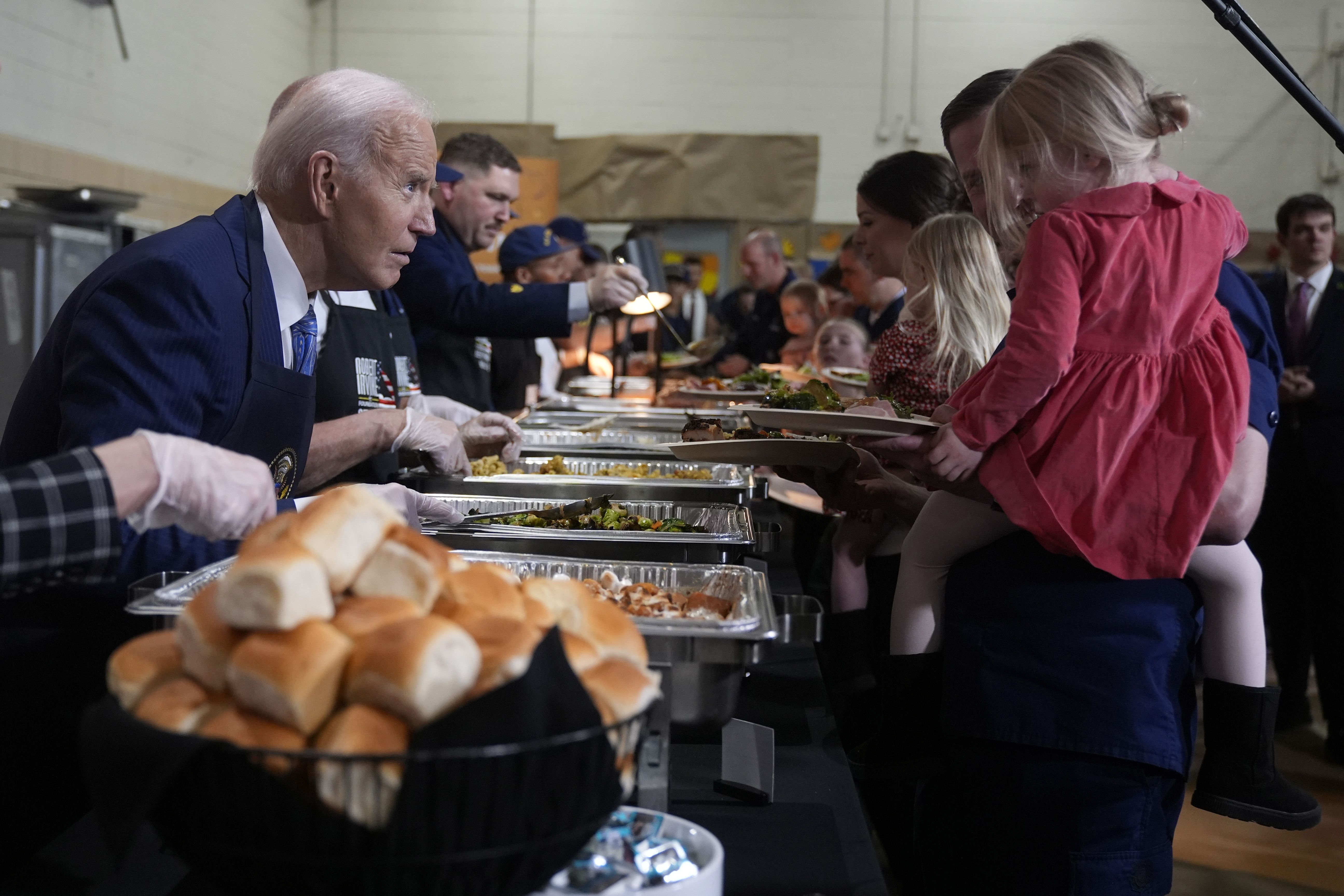 President Joe Biden, left, serves food at a Friendsgiving event with service members and their families in the Staten Island borough of New York.