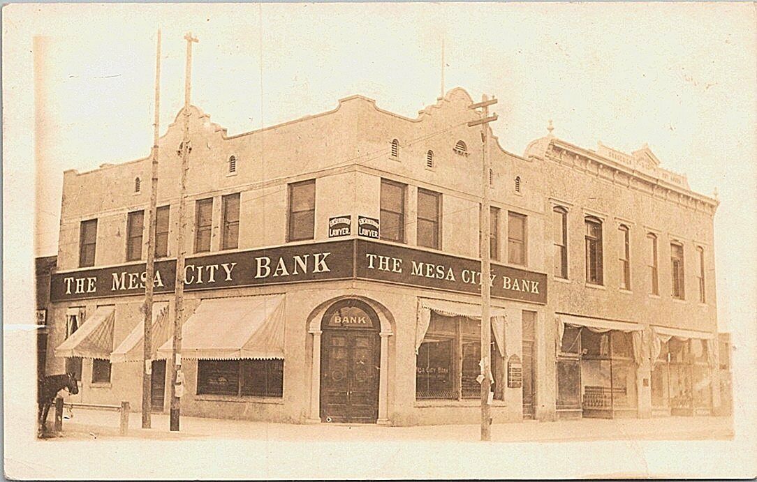 An archival photo of a building on Mesa main street that says "The Mesa City Bank" 