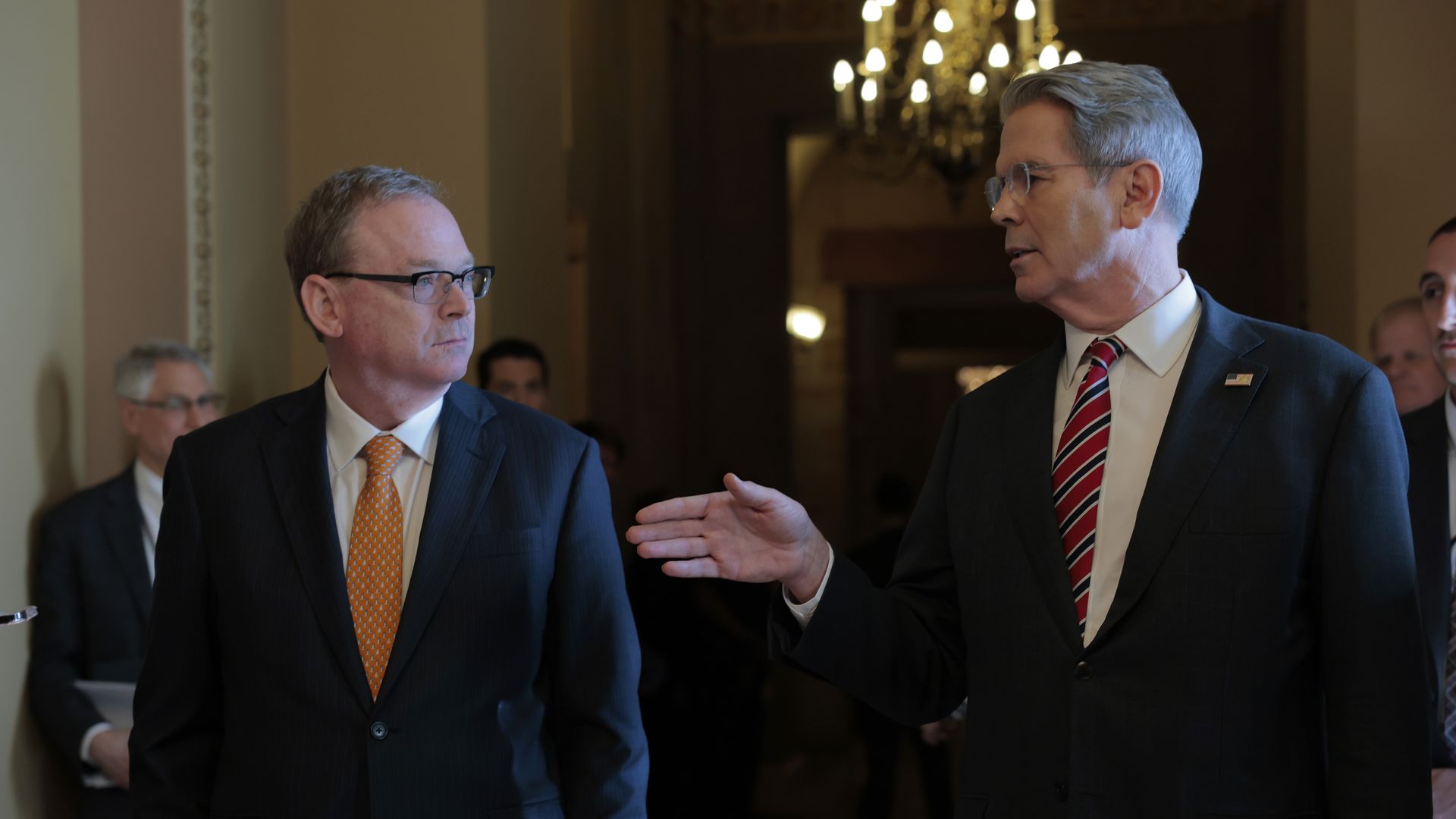 Scott Bessent at right, gesturing to Kevin Hassett, seen at left.