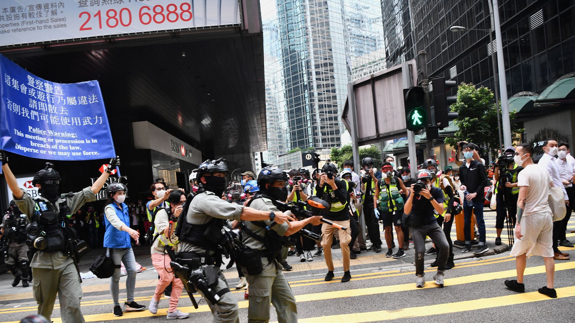 Hong Kong riot police (L) issue a warning as they plan to clear away people gathered in the Central district of downtown Hong Kong on May 27