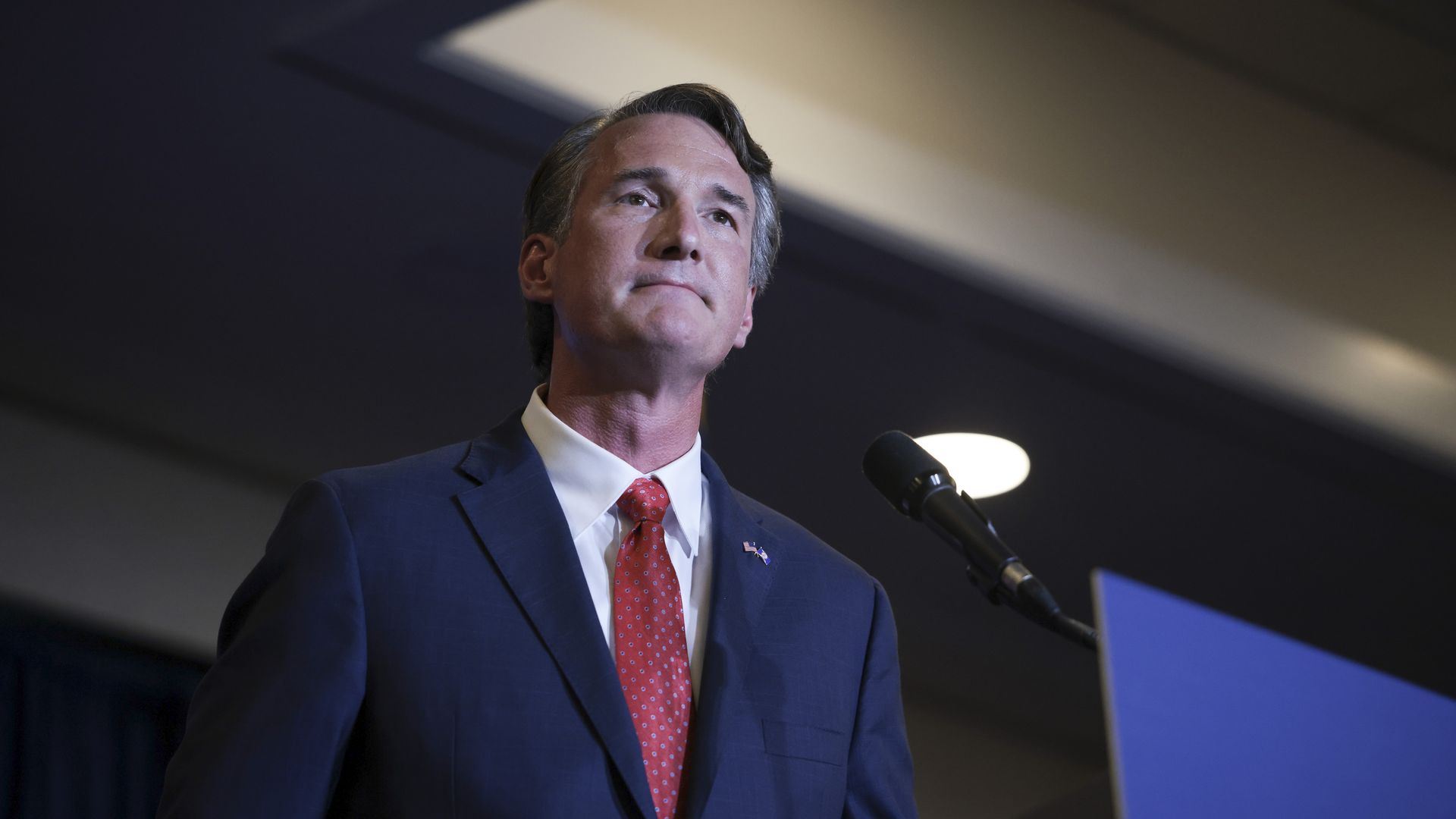 Photo of Glenn Youngkin in a suit standing on a podium