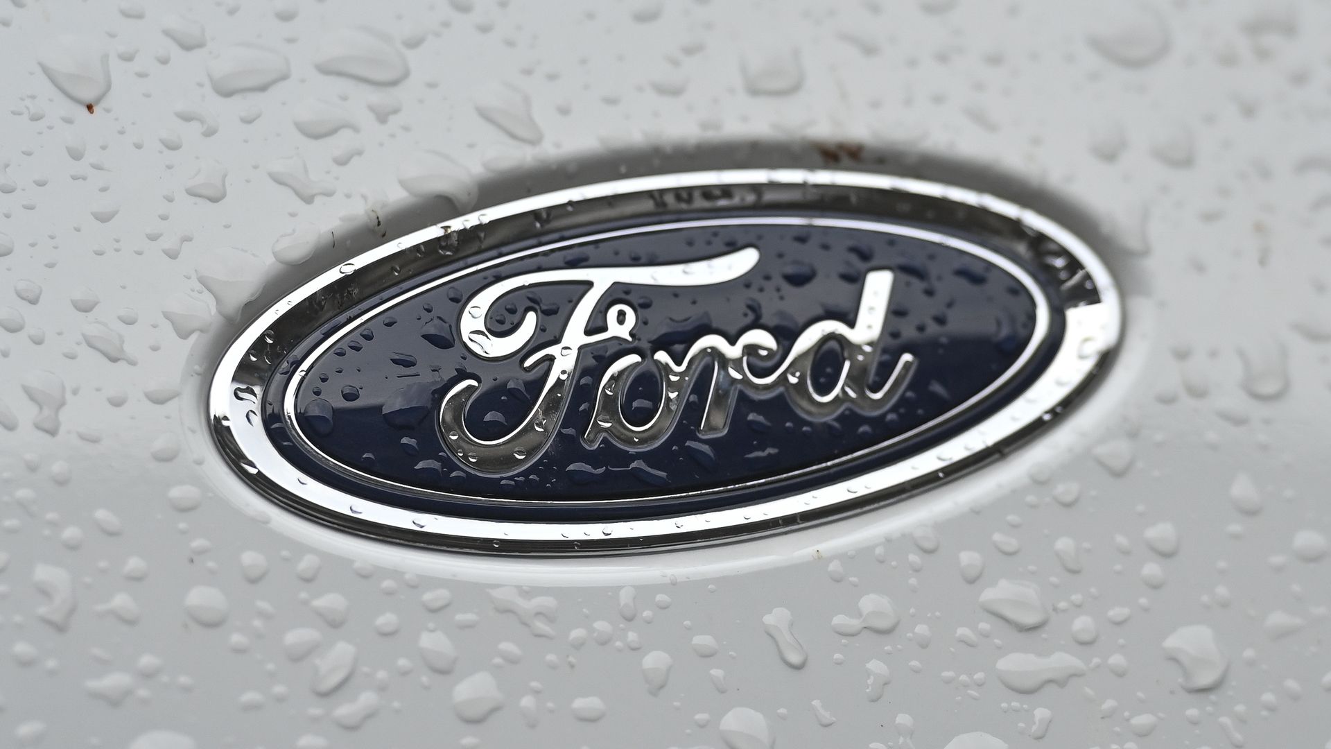 Rain drops on the blue-oval logo of Ford