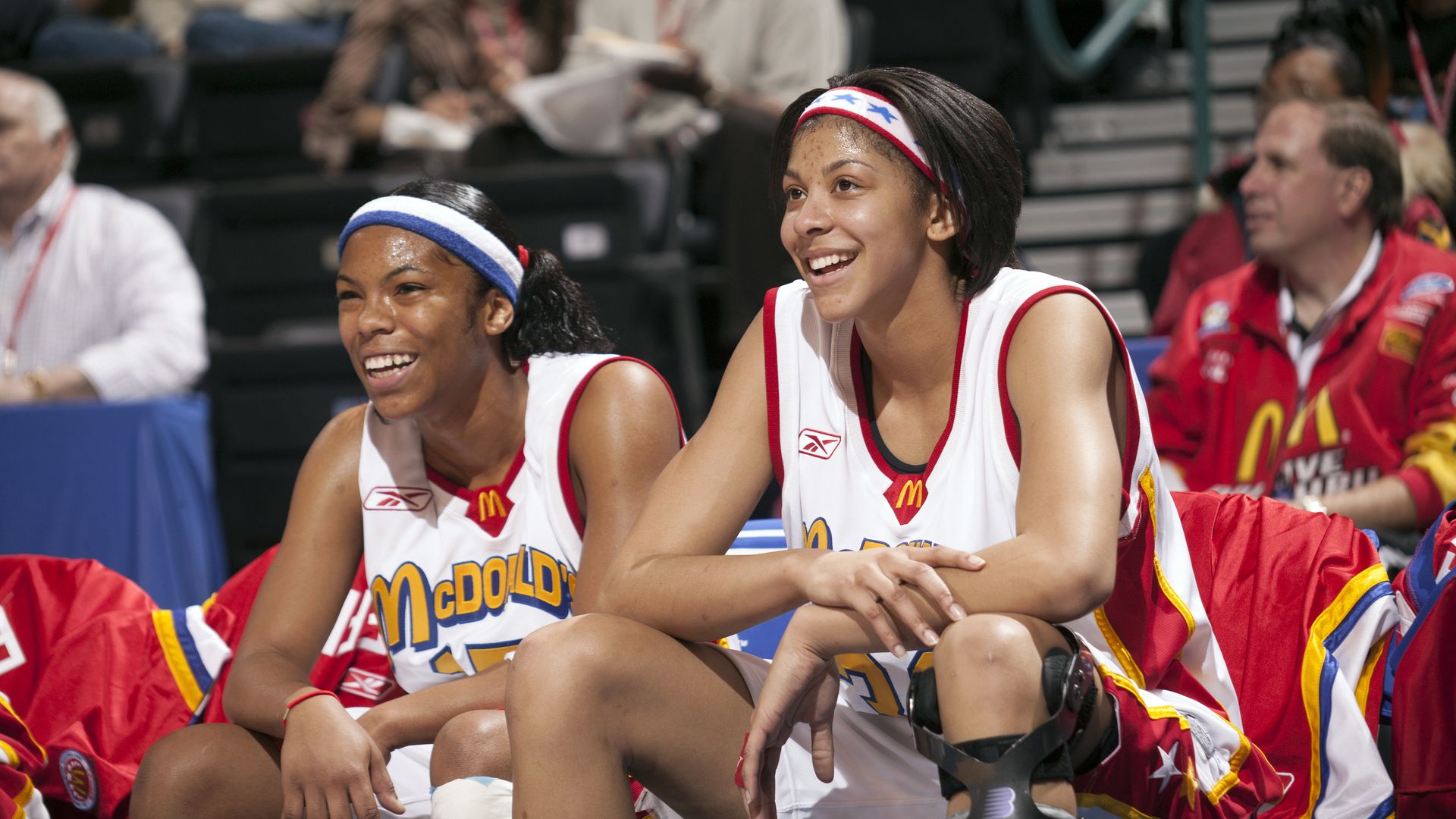 Candace Parker sits on a chair at a basketball game.