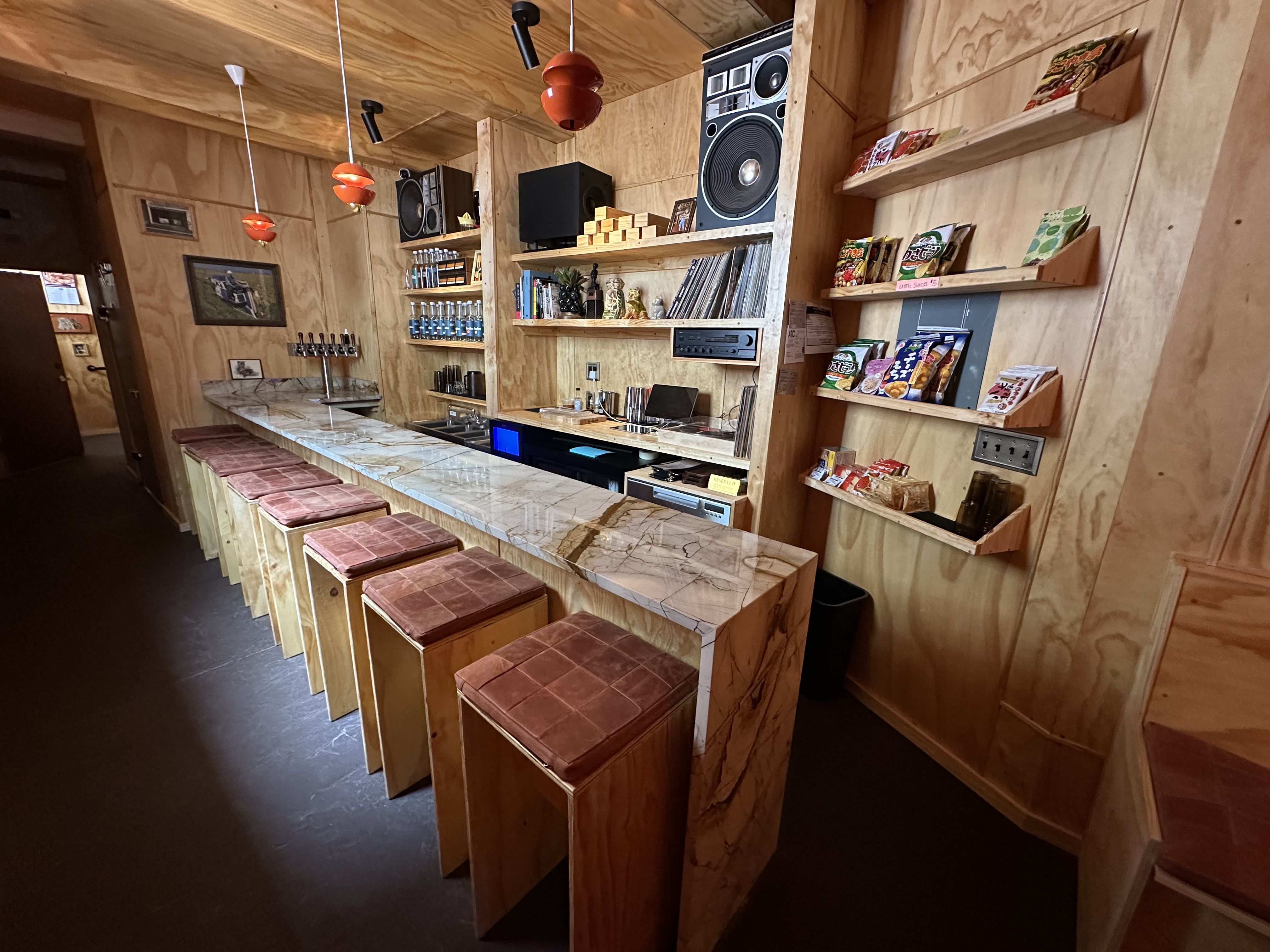 The interior of a wood-paneled, modern-designed bar.