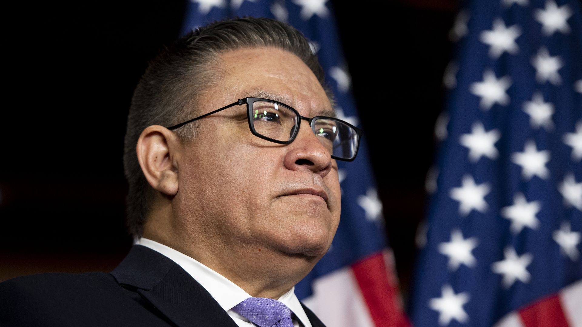 Rep. Salud Carbajal, D-Calif., stands in front of American flags at the Problem Solvers Caucus press conference in the Capitol.