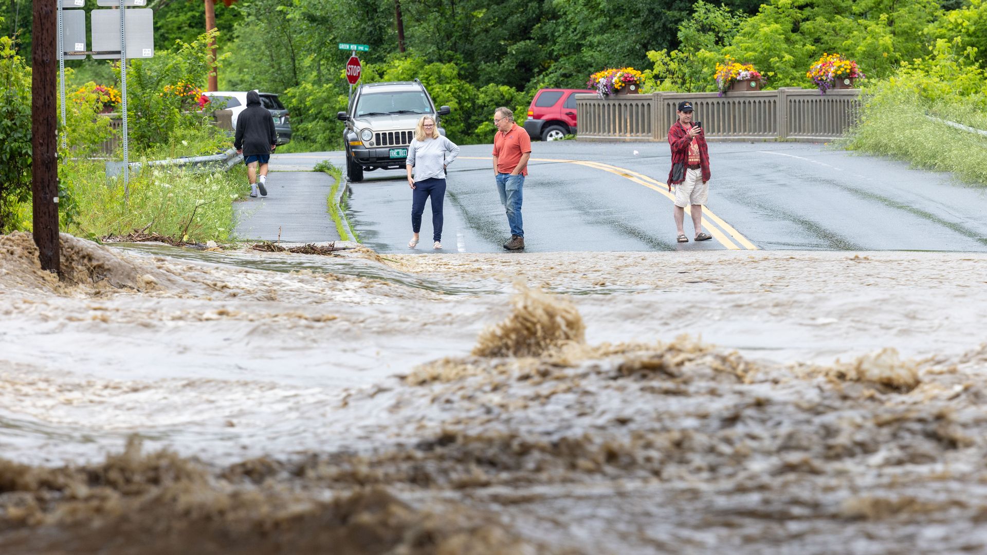 Onlookers check out a flooded road on July 10, 2023 in Chester, Vermont. 