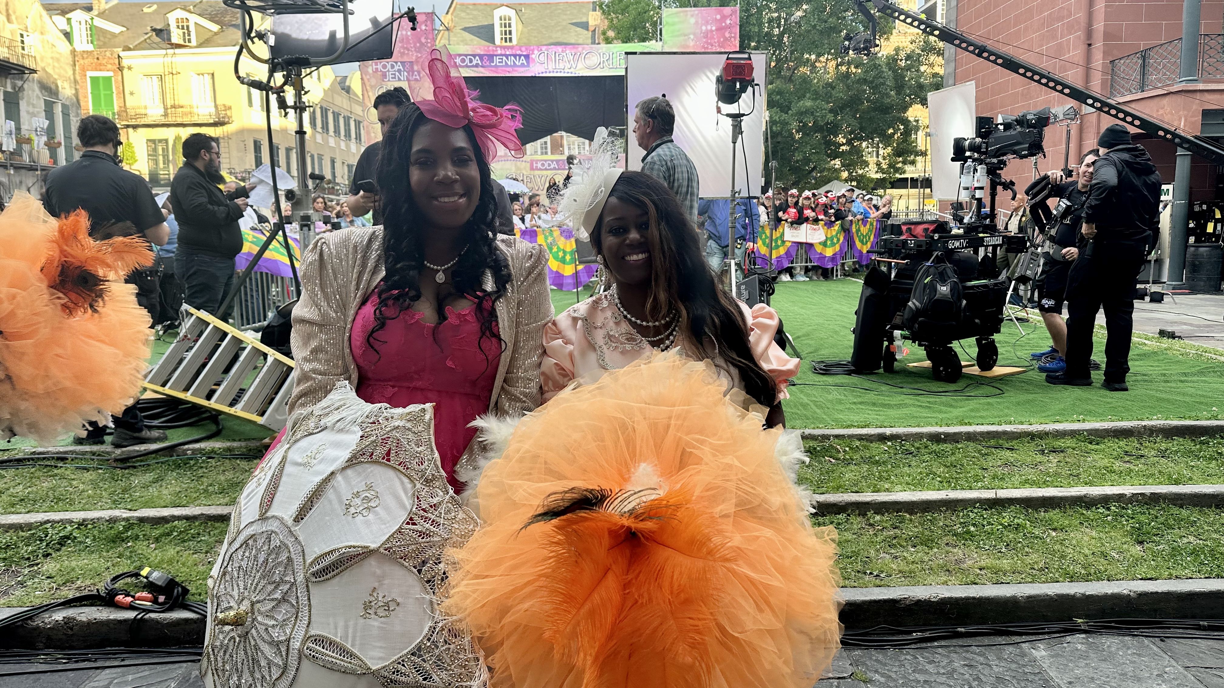 Photo shows two New Orleans baby doll dancers with umbrellas and festive clothes.