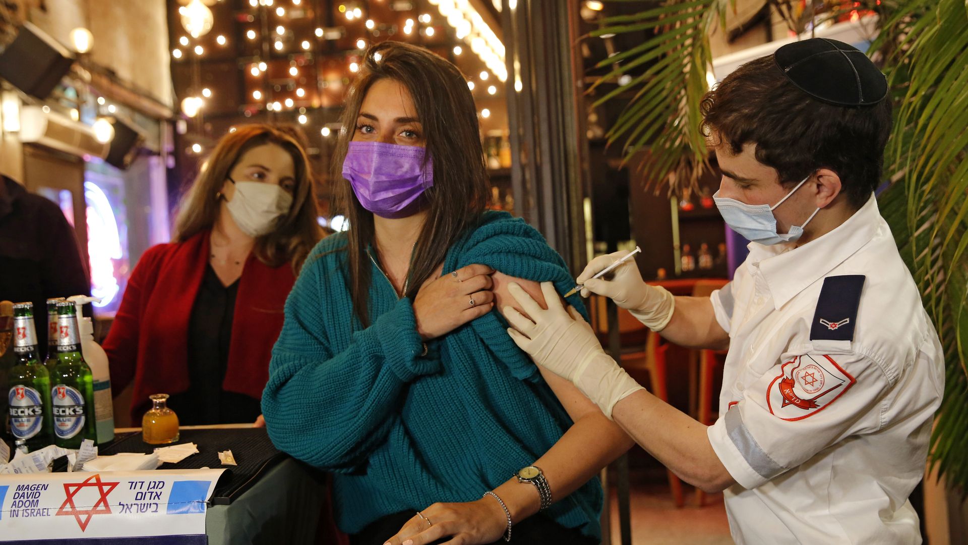 A health worker administering a COVID-19 vaccine to an Israeli at a bar in Tel Aviv on Feb. 18.