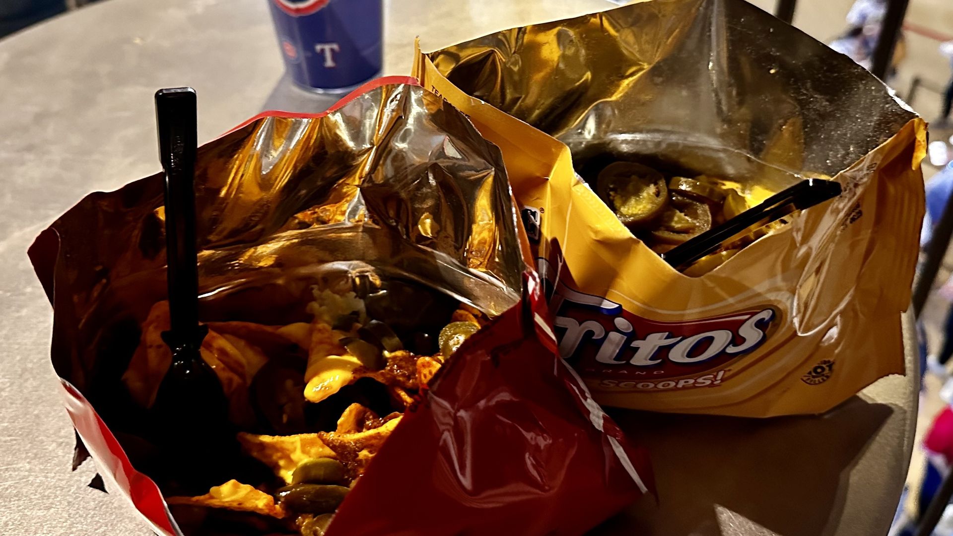 Two cut-open bags of chips with chili and chips inside