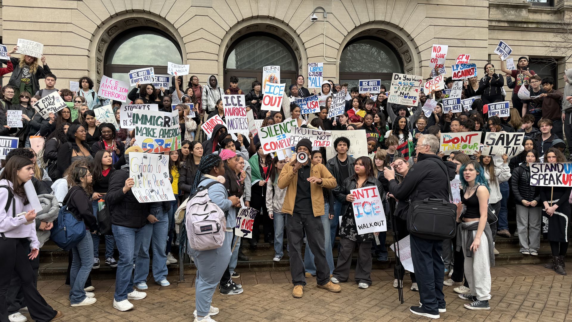 students with signs on a step