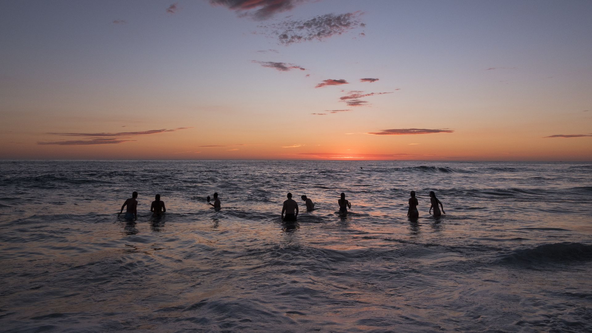 SAN DIEGO, CALIFORNIA - SEPTEMBER 9: People wade in the Pacific Ocean at La Jolla's Windansea Beach at sunset on a hot and humid summer day as large surf generated by Hurricane Marie slams the Southern California coast on September 9, 2026 in San Diego, CA. (Photo by Kevin Carter/Getty Images)