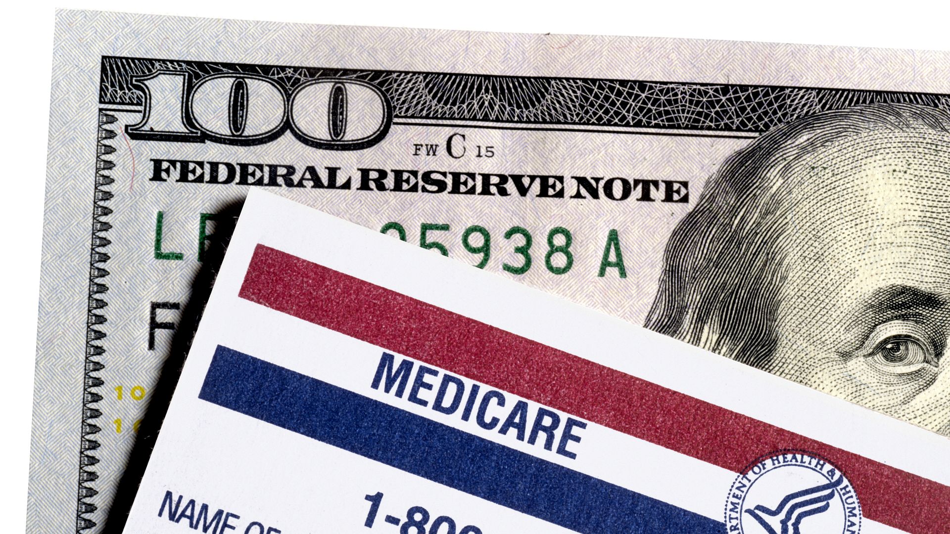 Medicare card in front of a hundred dollar bill