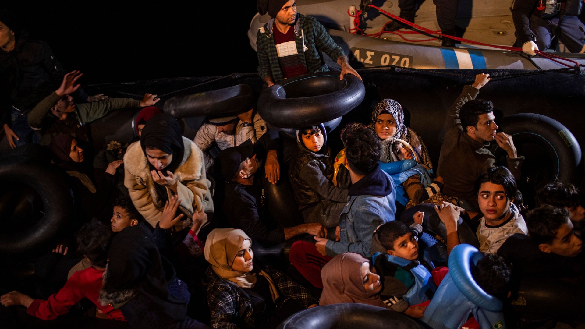 Worried-looking migrants from the Middle East are rescued at sea