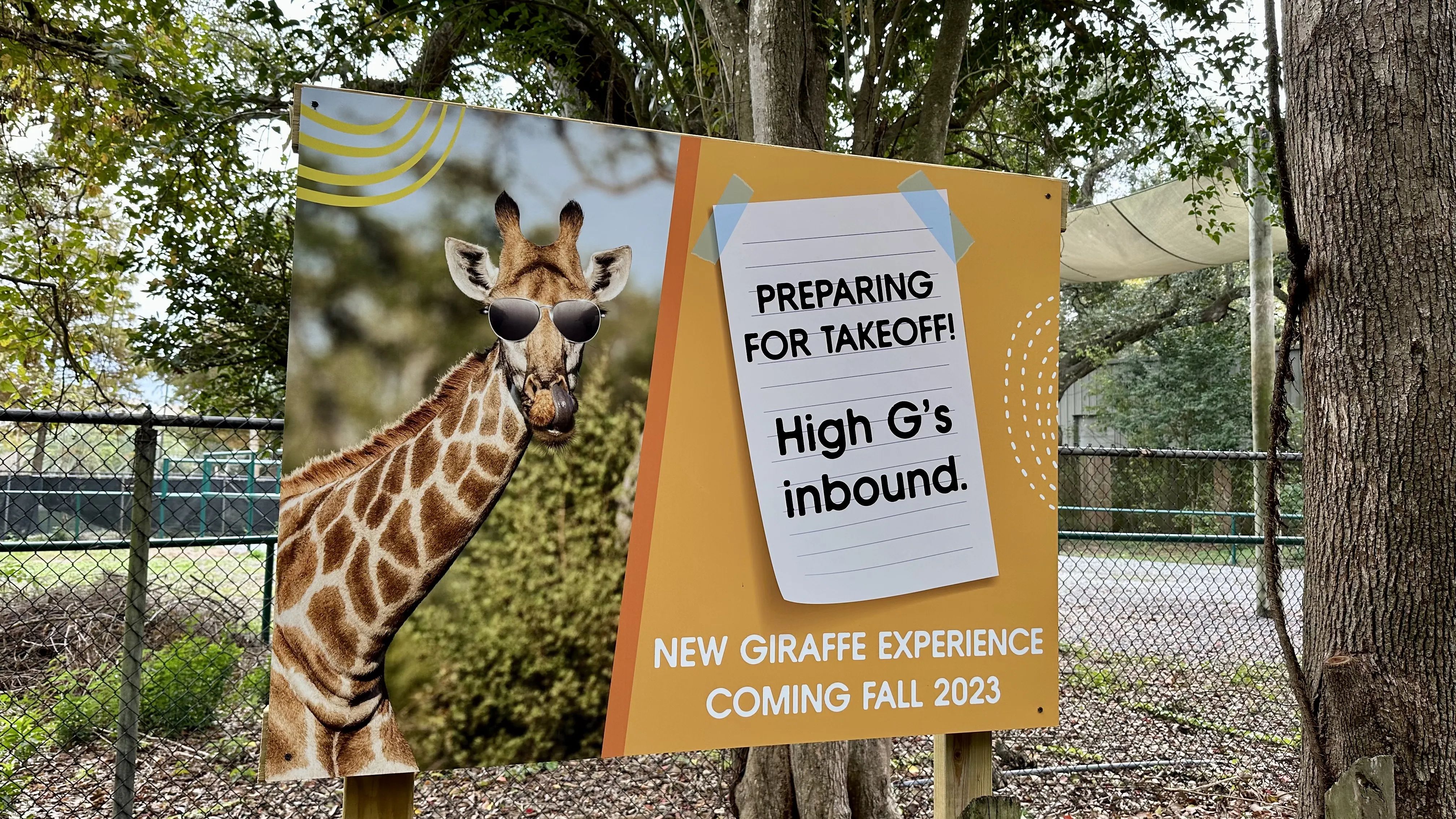Photo shows a sign advertising the new giraffe experience coming to the zoo