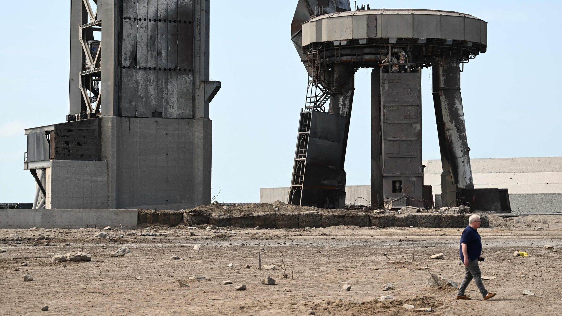 A person walking through a debris field in front of SpaceX's Starship launch pad in Boca Chica, Texas, on April 22.
