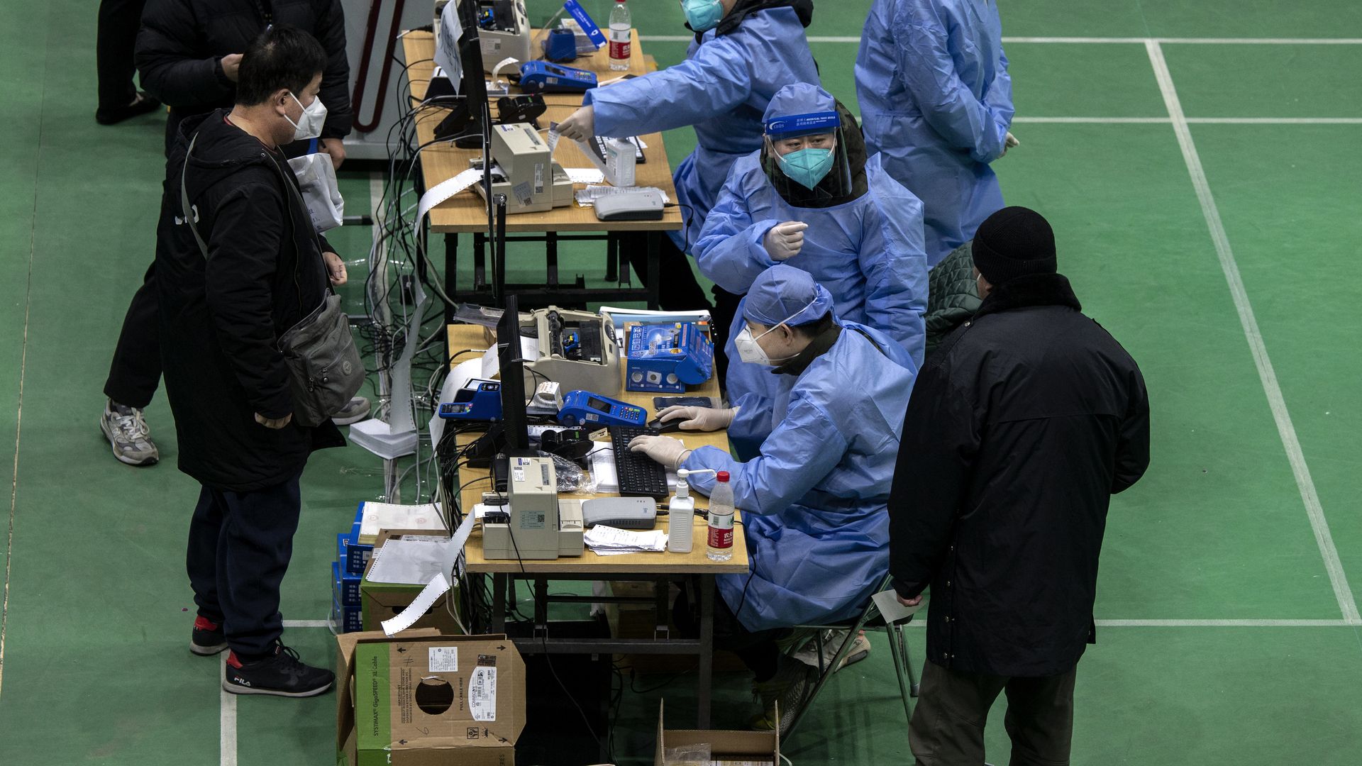 Health workers register people at a temporary fever clinic set up by a hospital to treat potential COVID-19 patients in a sports centre on December 18, 2022 in Beijing. 