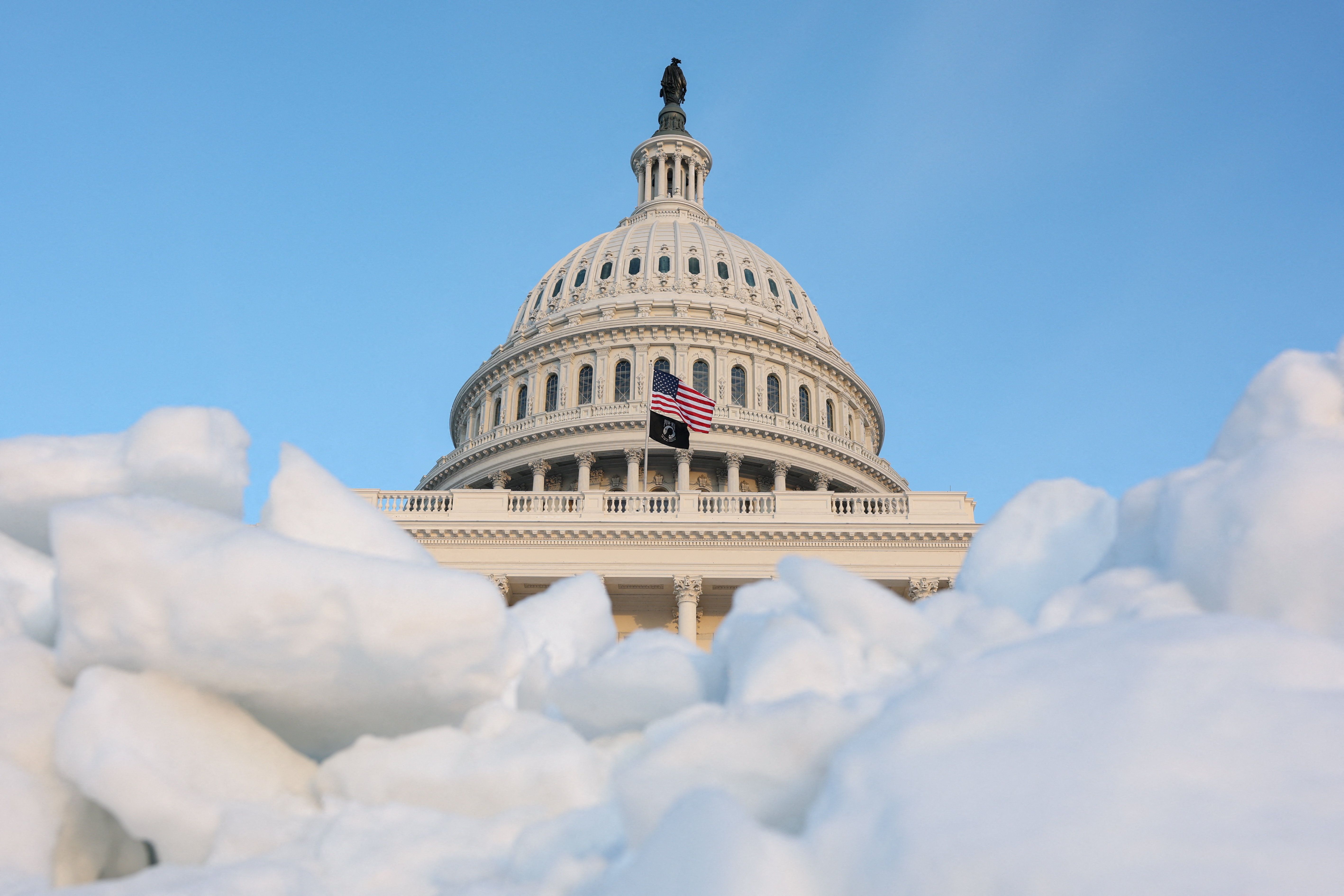 The sun sets on the U.S. Capitol building near a pile of snow and ice, as members of Congress work to resolve a dispute over immigration enforcement and avert a looming partial government shutdown, on Capitol Hill in Washington, D.C., U.S., January 30, 2026. REUTERS/Kylie Cooper TPX IMAGES OF THE DA