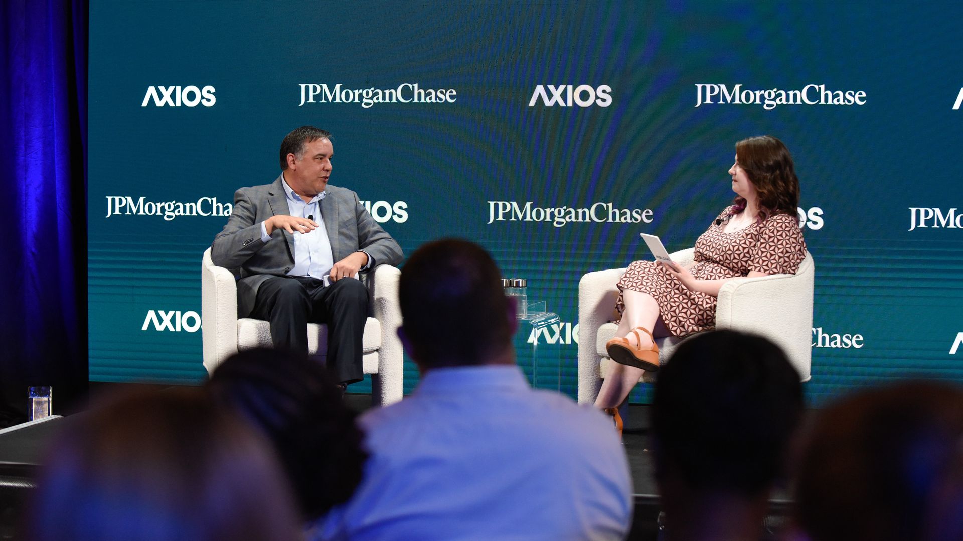 Alissa interviews Columbus Mayor Andrew Ginther. Both are seated in white chairs in front of a crowd, with a backdrop that reads "Axios" and "JPMorganChase" repeatedly.