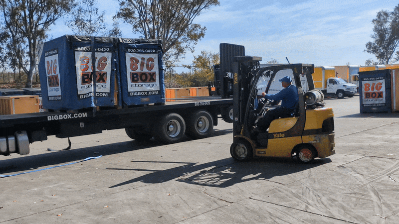 A forklift prepares to unload a storage cube at Big Box Storage.