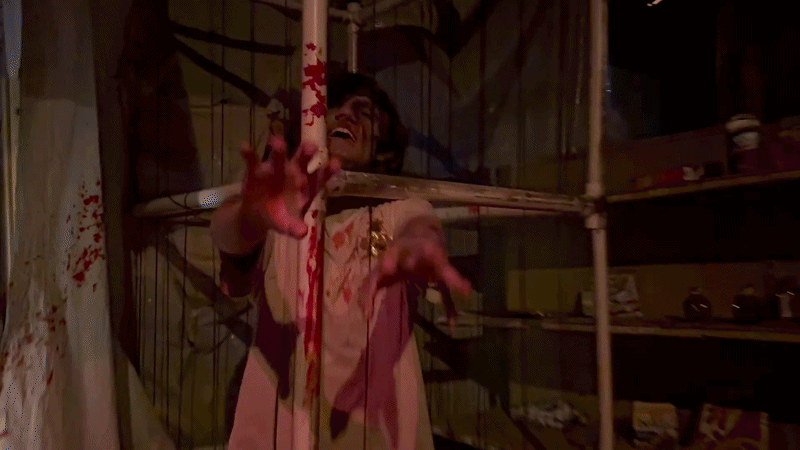 Halloween Haunt actor reaches through bars. 