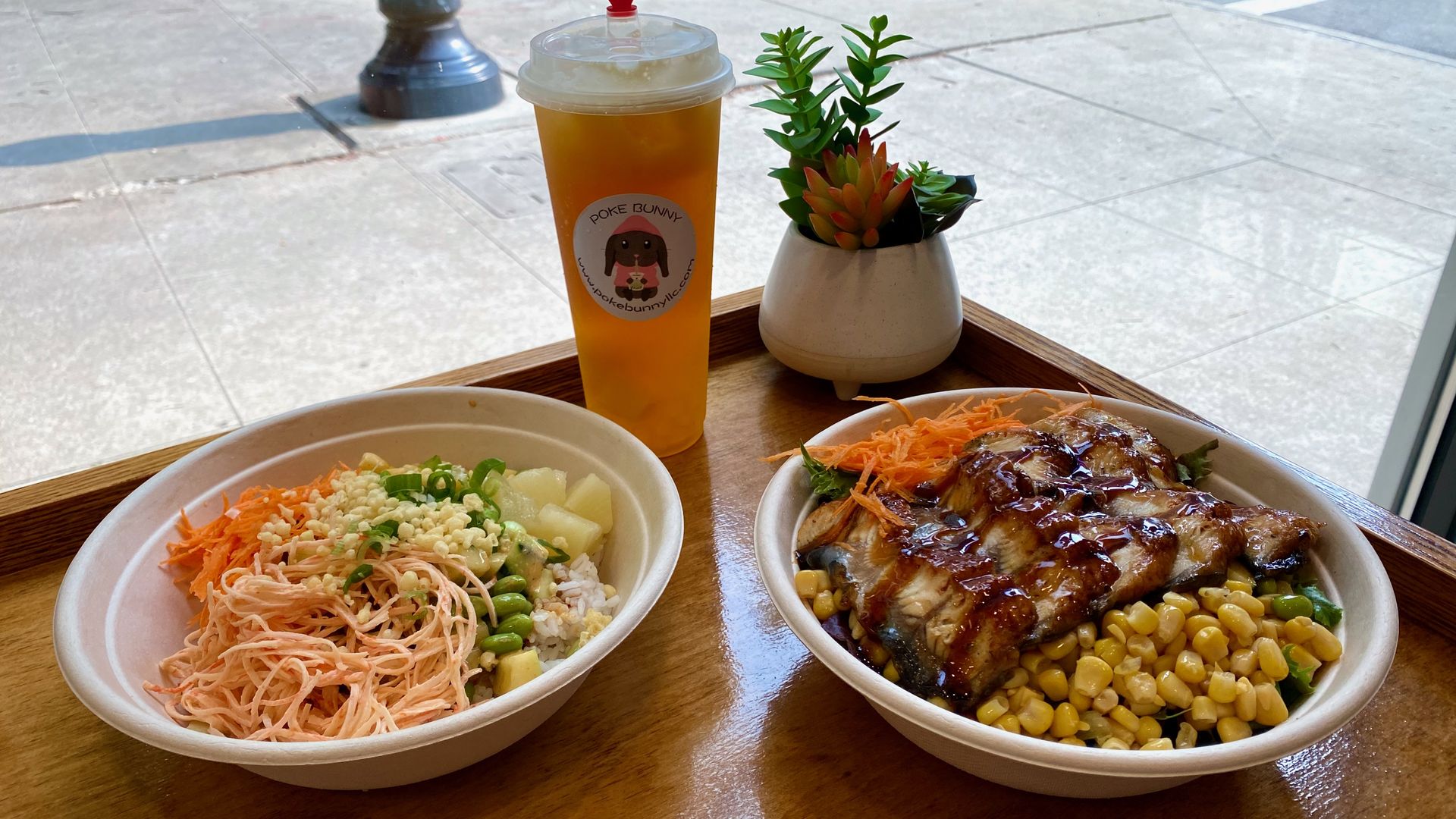 Two poke bowls and a drink on a table. 