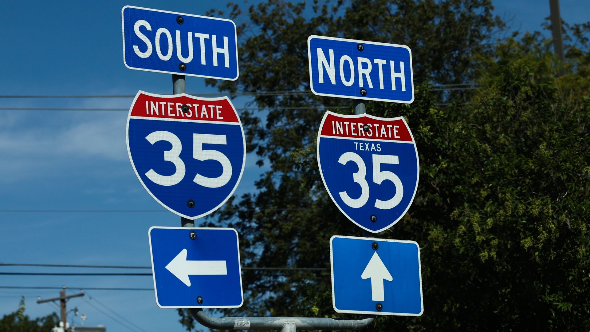 Blue highway signs show I-35 South to the left and I-35 North straight ahead.