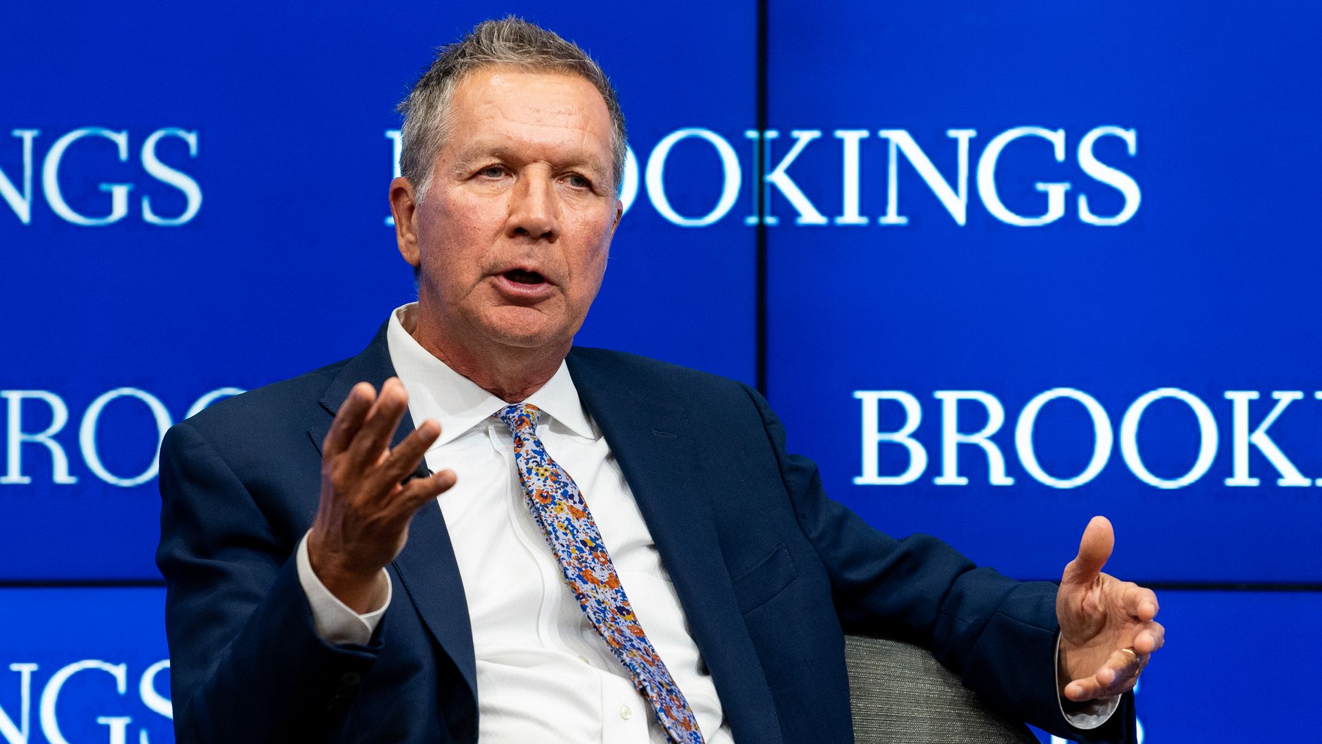 John Kasich sitting on stage