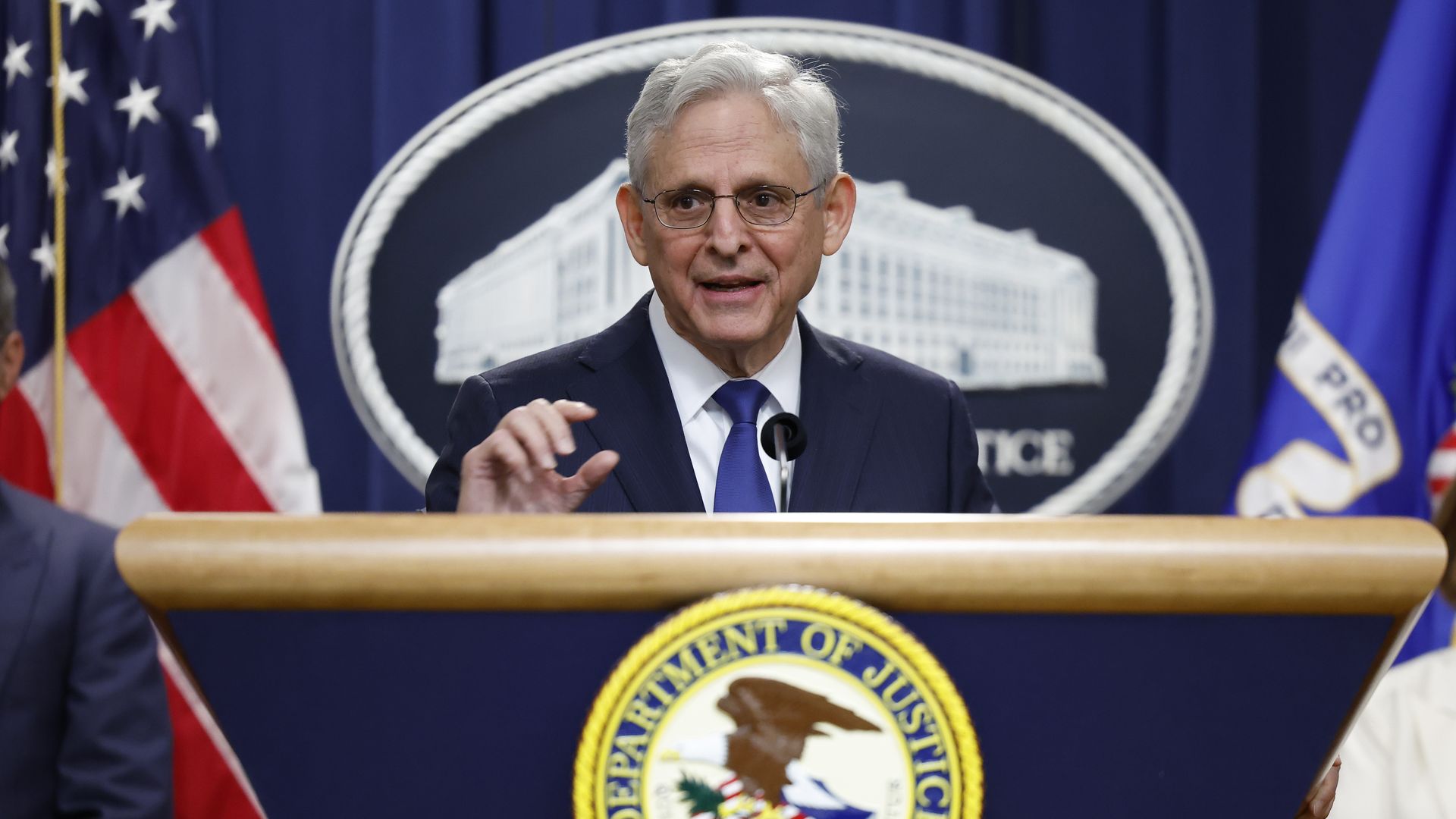 AG Garland speaks from a podium.