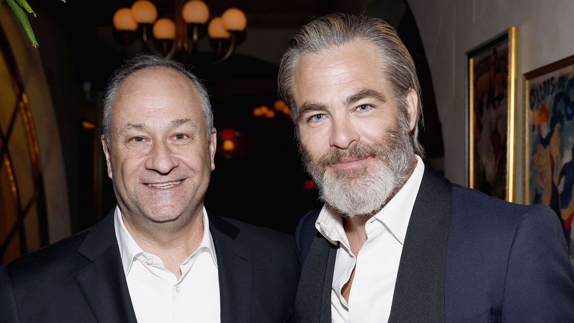 Dough Emhoff and Chris Pine smile at the camera.