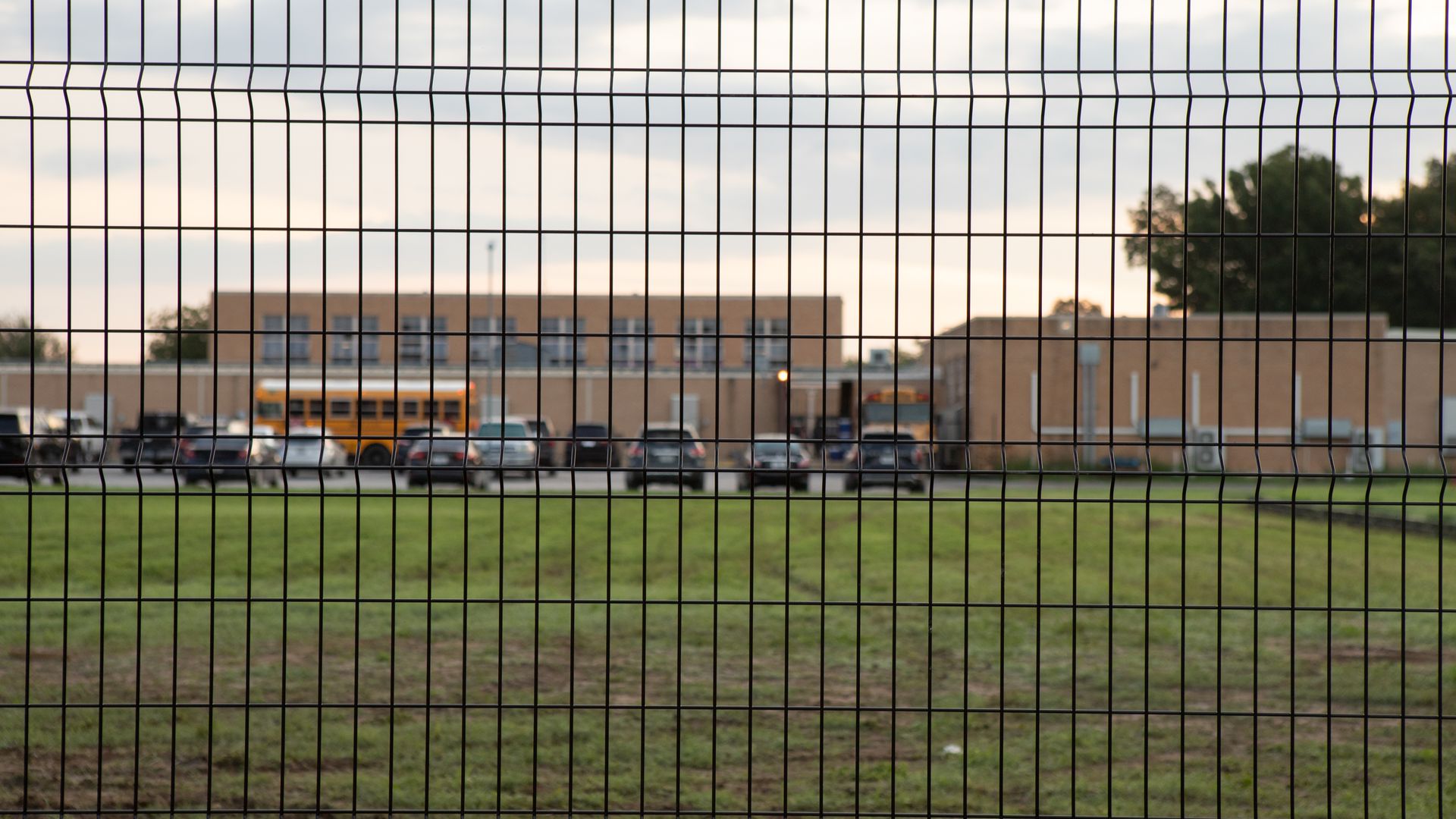 A view of the faculty parking lot of Flores elementary surrounded by the 8 foot tall fencing the school district as students go back to school months after deadly US shooting in Uvalde, Texas.