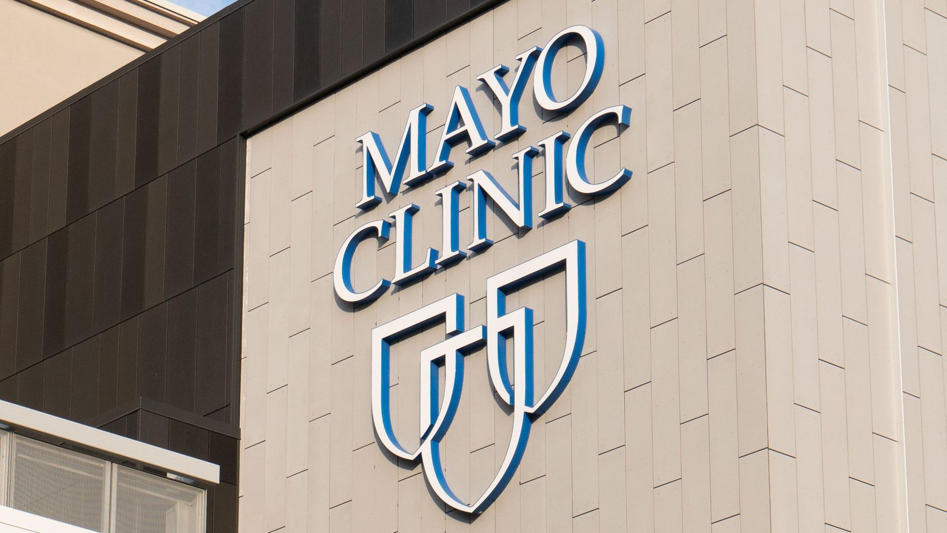 An exterior shot of a Mayo Clinic building showing their logo.
